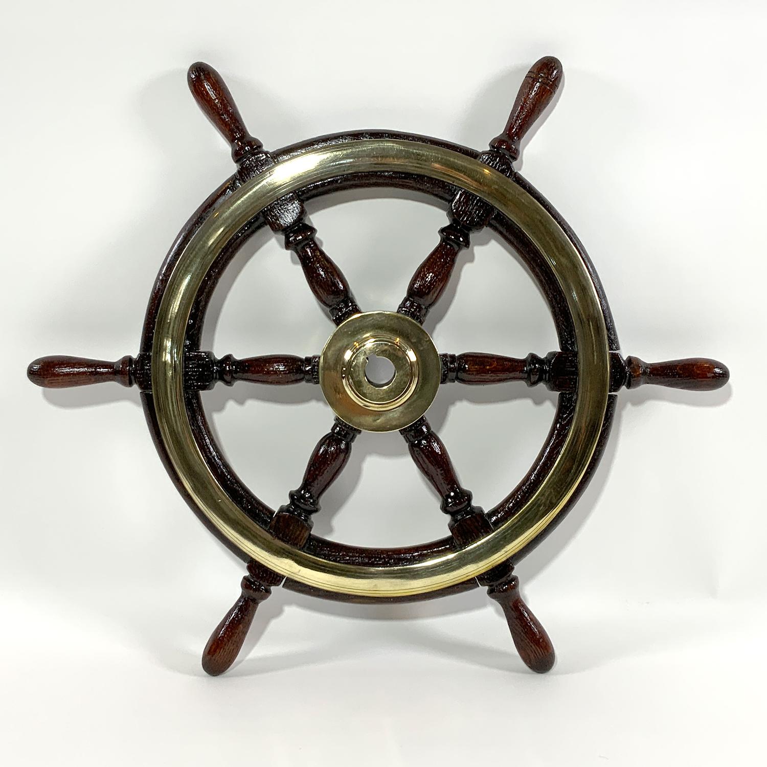 Antique late nineteenth century yacht wheel with heavy brass hub and brass trim rings. Rich hardwood with varnish finish. Quality relic. Circa 1895. Six carefully turned spokes and handles. Ready for display.