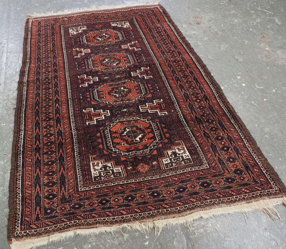 Antique Baluch rug by the Yaqoub Khani sub tribe with octogen medallion design
Circa 1900

The rug has four large turreted octogen guls on a rich aubergine coloured ground Note the traditional Yaqoub Kahani design on a white ground in each of the