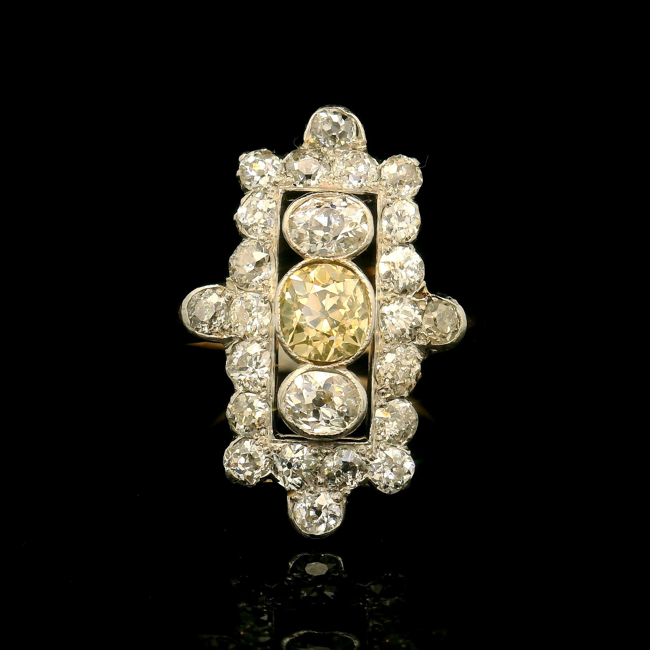 Yellow and white gold 18 Karat ring. 

Ring set with a center old mine intense yellow diamond of approximately 0.75 Carats, two old oval shape diamonds for a total of approximately 0.45 Carats and 22 old European cut diamonds for a total of