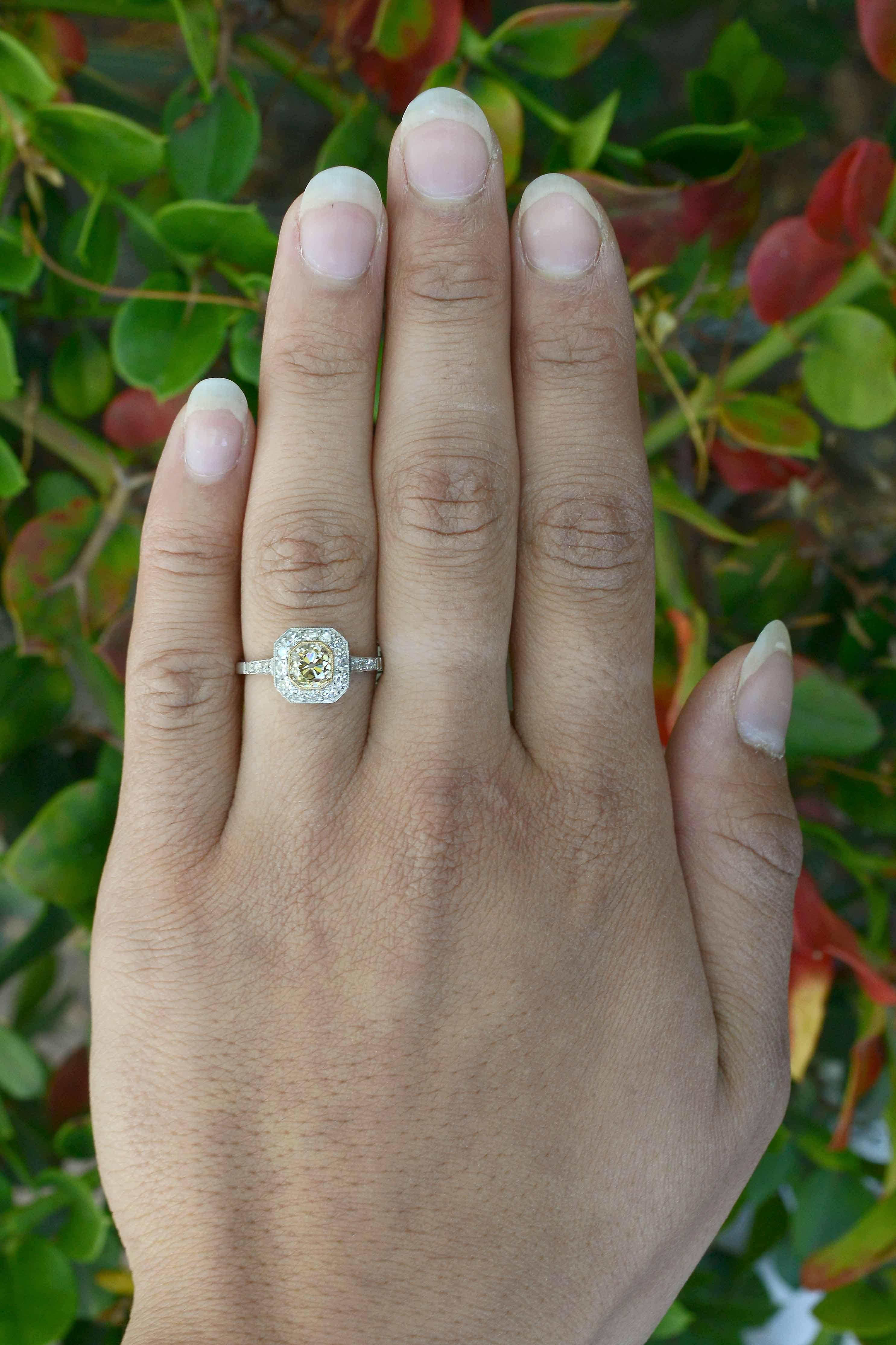 Fashioned in an Art Deco target style and centered by a dreamy, brilliant, old mine cushion cut yellow diamond of just under 1 carat with those juicy, large facets that flash beams of sparkling light everywhere.

With a dainty, milgrain-kissed bezel