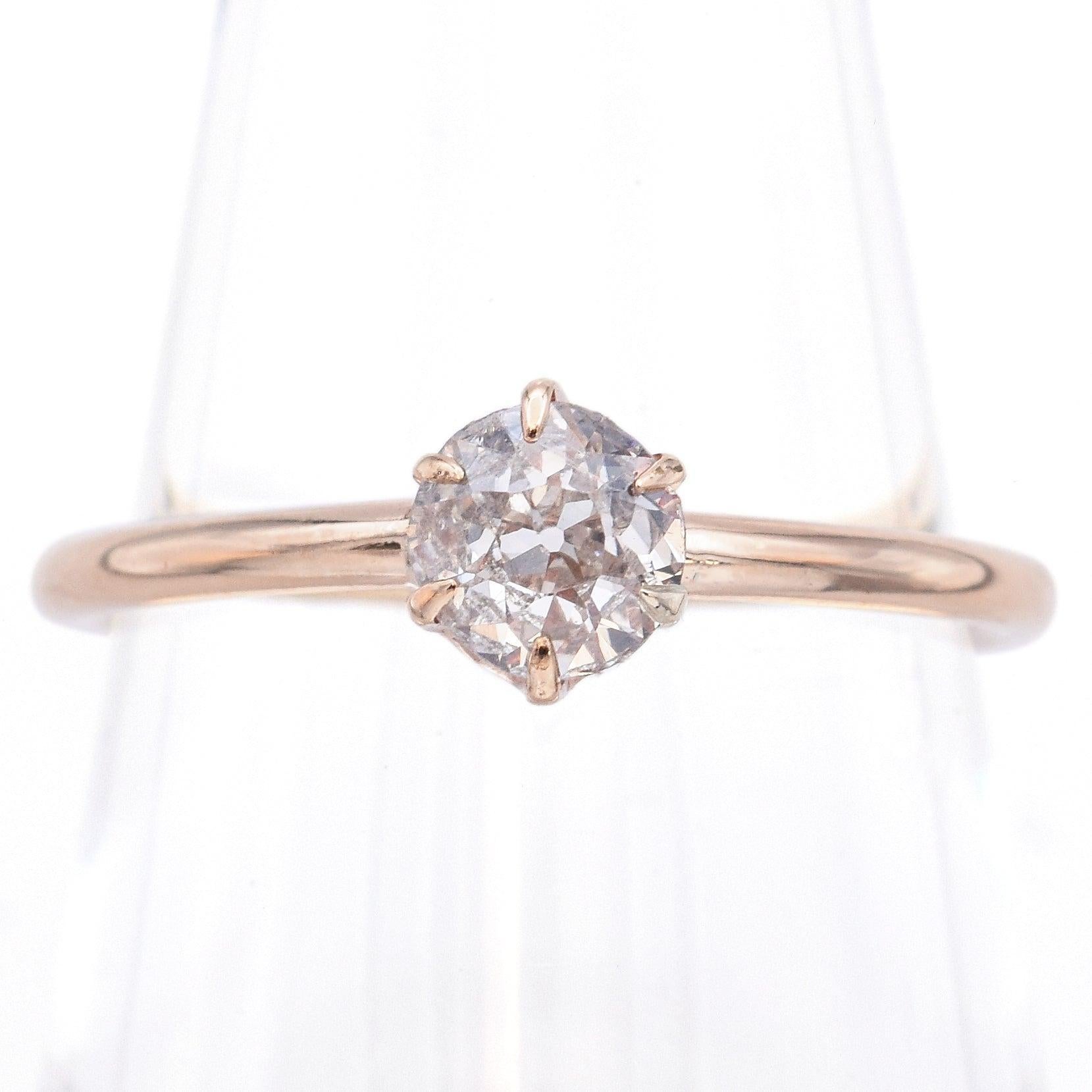 Sobre et romantique, cette bague de fiançailles solitaire ancienne présente un diamant lumineux de taille européenne ancienne serti dans une monture classique à six branches. Réalisée en or jaune aux teintes douces et dotée d'un anneau fin et poli,