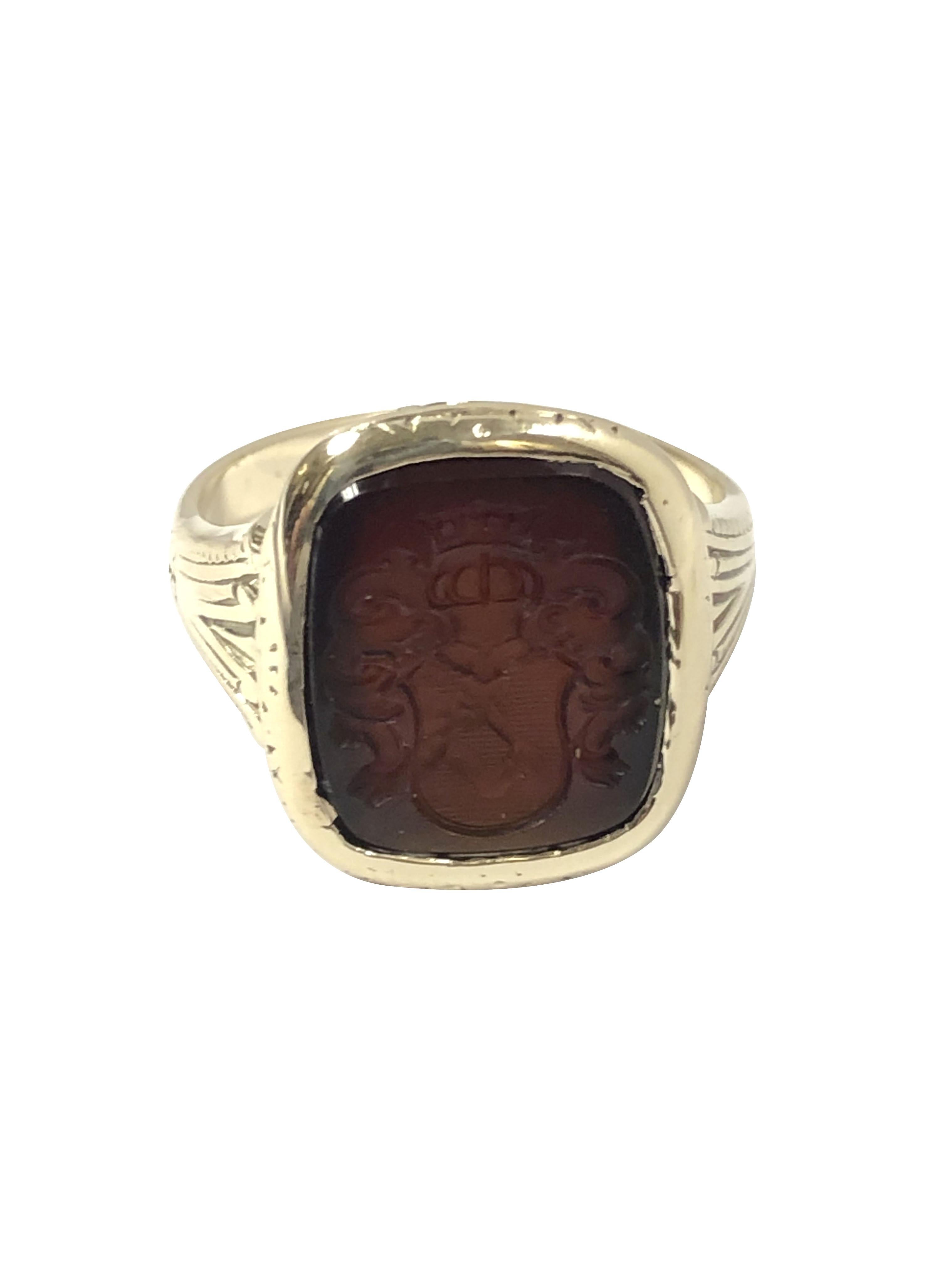 Circa 1890 - 1900 14k Yellow Gold Crest Ring, the top measuring 5/8 x 1/2 inch and is set with a deep Red / Brown Carnelian with a deep engraved Crest. the ring features hand engraving design work throughout. Finger size 7 1/4. 