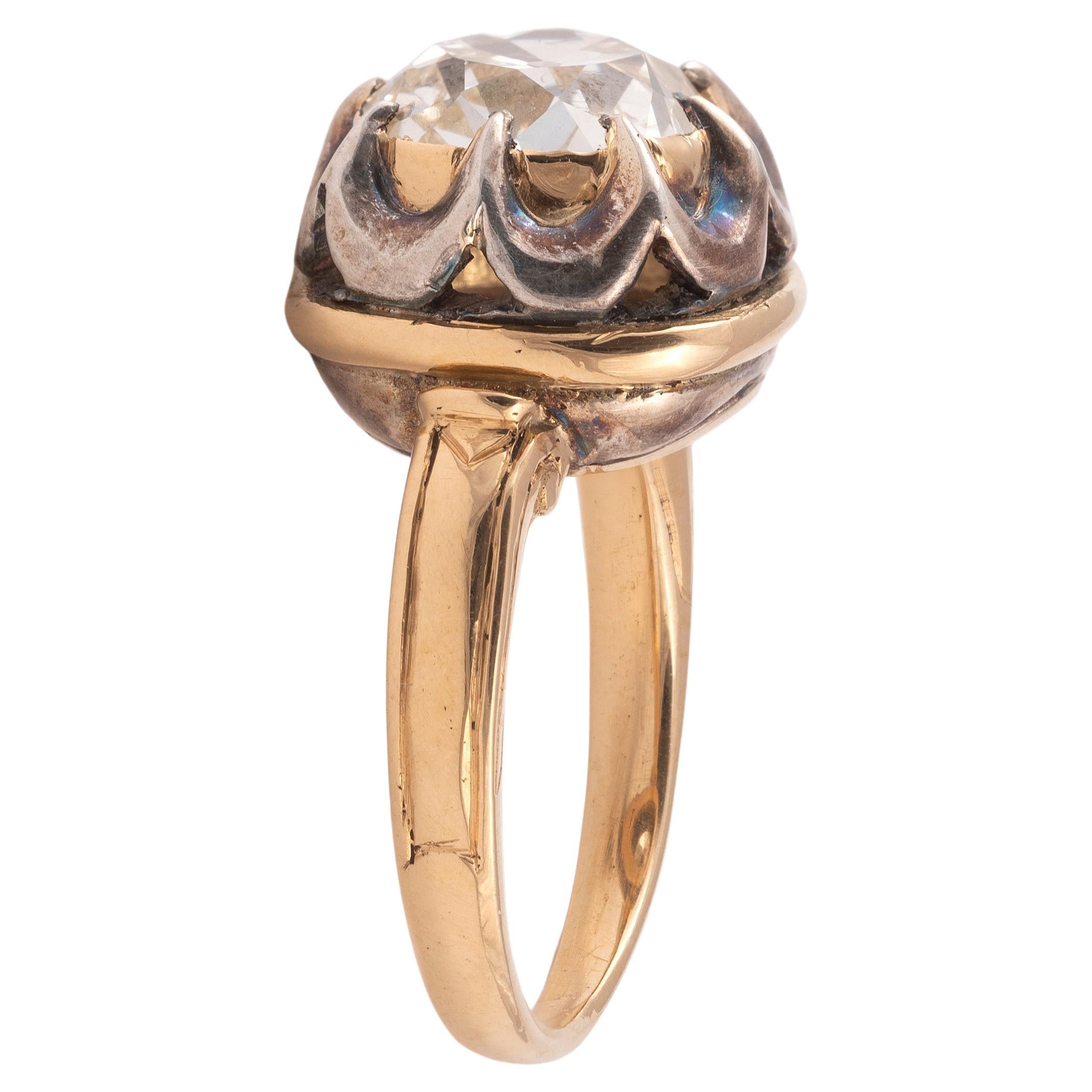 The old-cut cushion shaped ,4ct approximately, to diamond-set claws and silver and gold bezel surround, the tapering shoulders with plain decoration
Size : 7 1/4
Weight: 9,90gr.