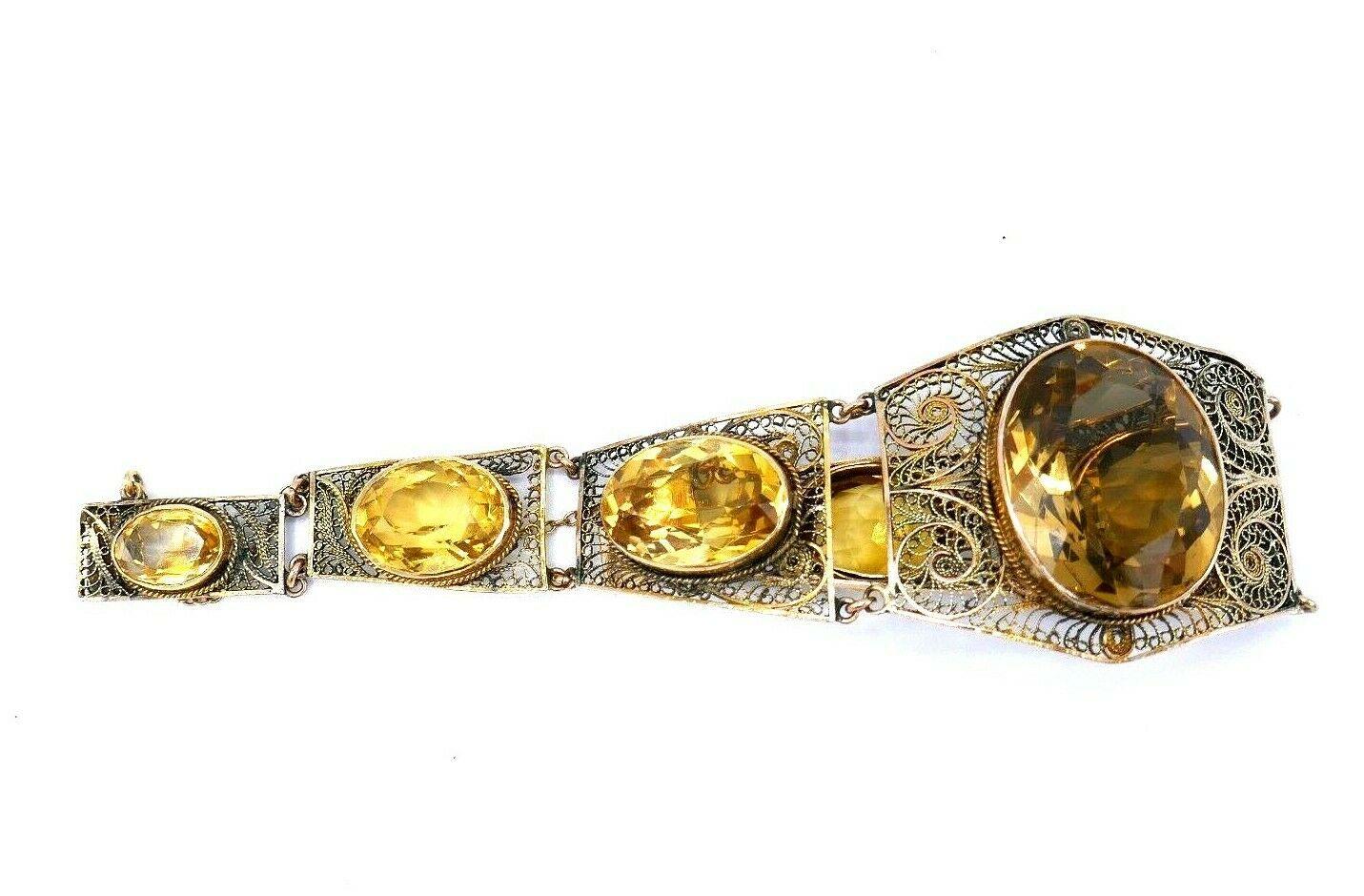 A gorgeous antique filigree bangle bracelet made of 14k yellow gold (stamped) featuring oval cut citrines. Comprises six links  connected by wire. 
Will fit up to 6