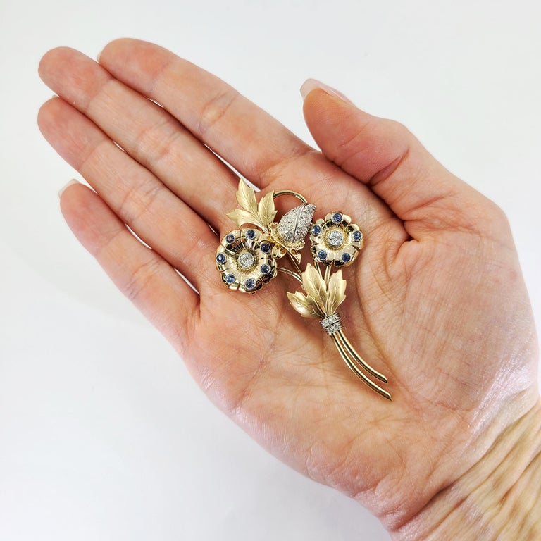 14 Karat Yellow Gold Flower Brooch Featuring 12 Round Sapphires Totaling Approximately 1.00 Carat, & 18 Old European and Single Cut Diamonds Totaling Approximately 0.50 Carats. Finished Weight Is 11.4 Grams. 2.75 Inches Long.