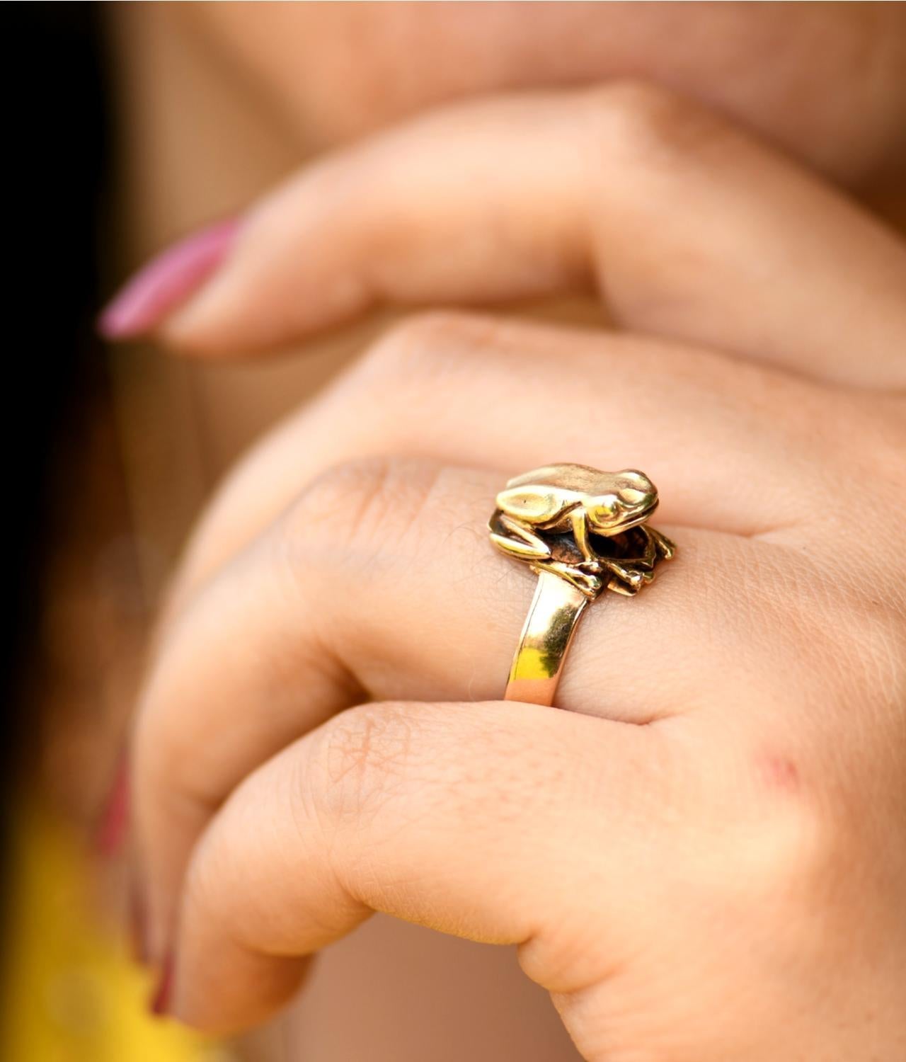 This ring has a very sweet, but life-like tree frog in 14 karat yellow gold. It is a simple design with the frog sitting directly on the band. It is sitting with its head looking up. The detail in the frog gives this ring real character. 

Gold frog