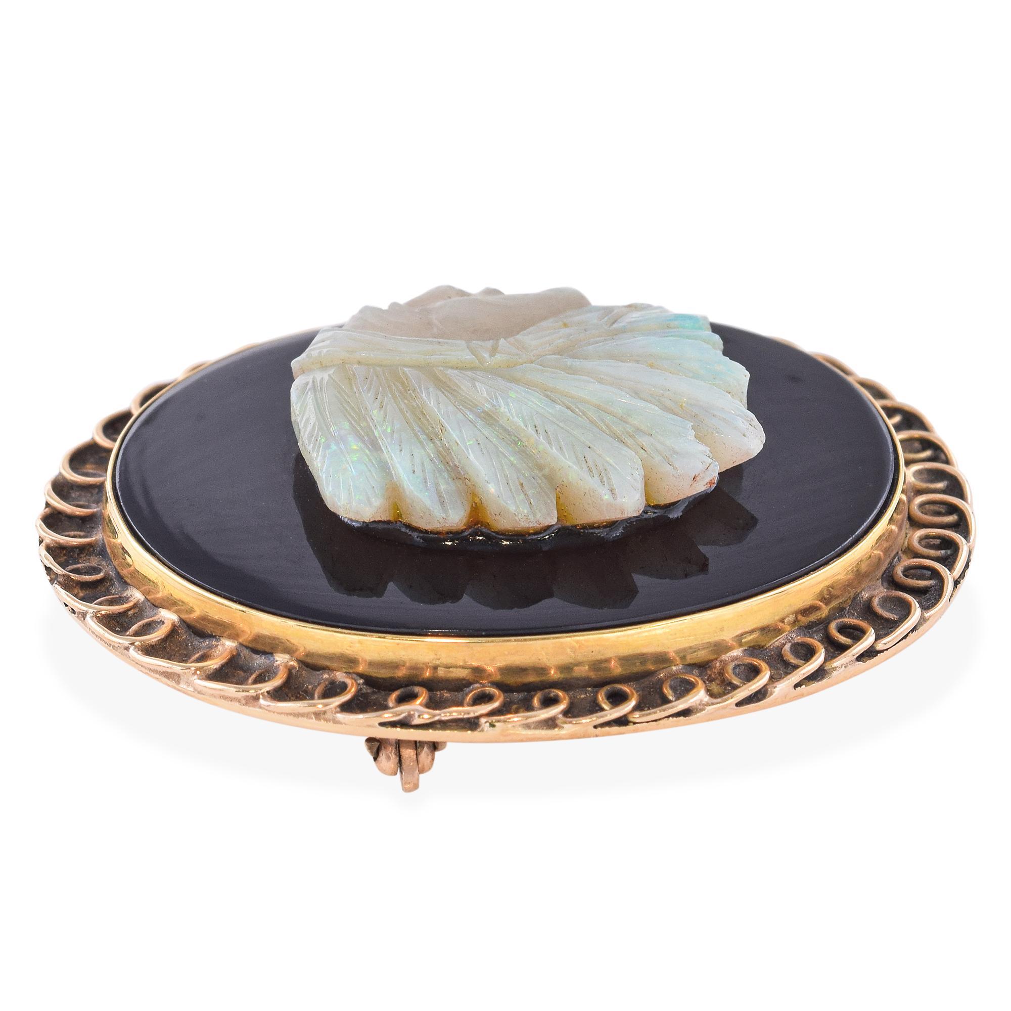 Broche-cadenas antique avec pendentif coulissant, représentant le profil finement sculpté d'un chef indien, réalisé en opale lumineuse sur onyx noir profond pour un contraste saisissant. Les détails complexes de l'expression noble du chef et de sa