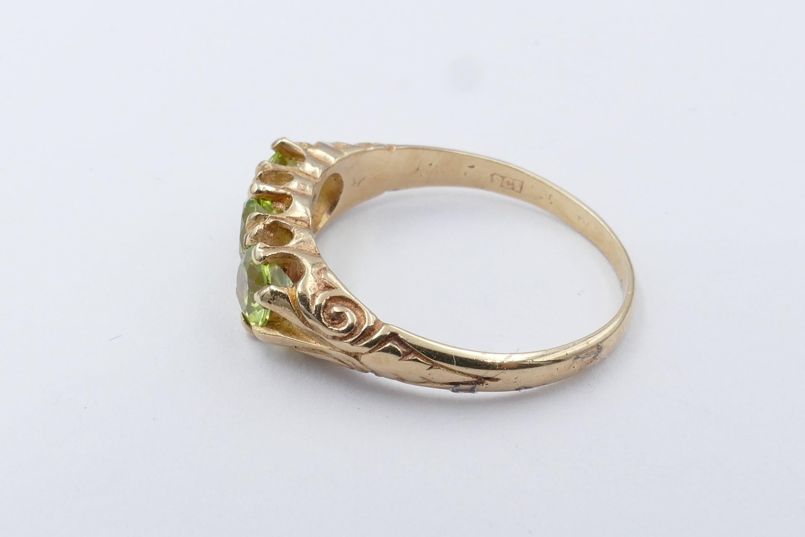 3 Medium light green Peridots are the Centrepiece of this traditional Victorian/Edwardian Band Ring.
The Stones are Round Cut, Clarity eye-clean, Claw Set in a Carved Foliate Gallery.
The Band is half round, reverse tapered, and measures 1.65mm wide