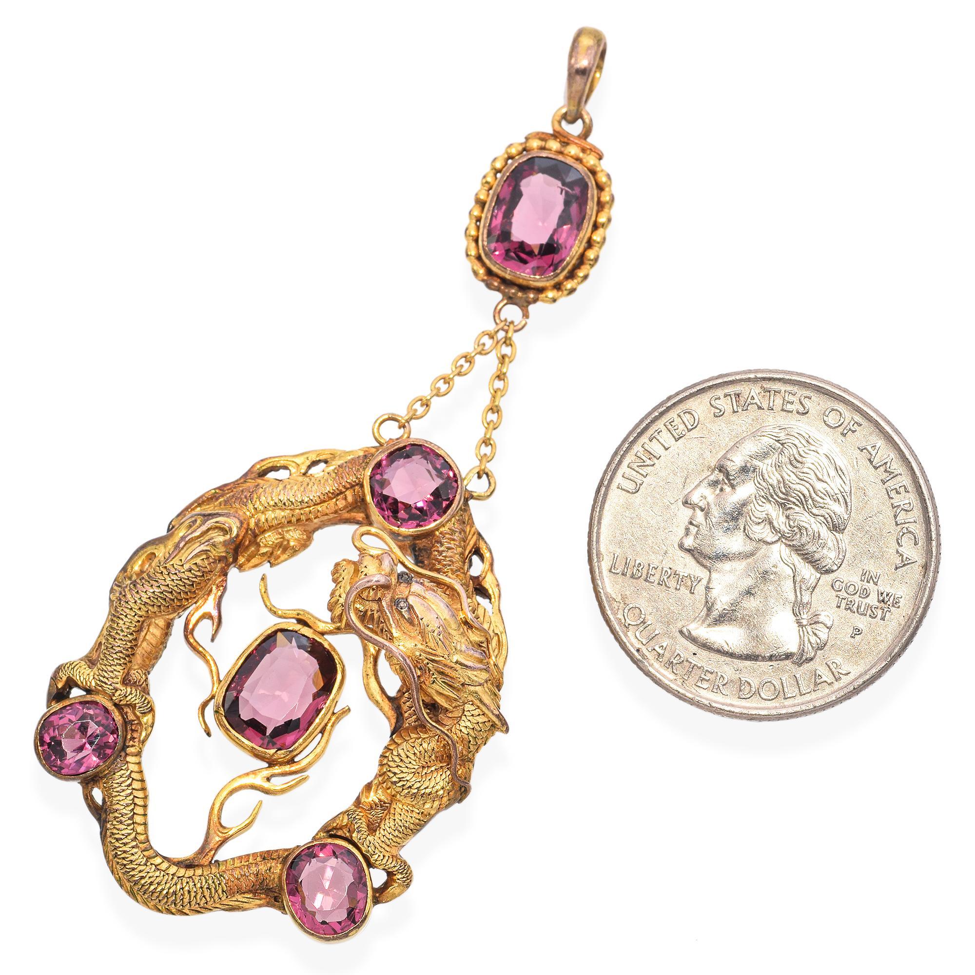 This Victorian dragon pendant is unlike anything we've ever seen before. Meticulously carved, the beautiful Asian dragon weaves gracefully around three round, velvety rhodolite garnet stones, with a larger cushion-shaped stone at its center. The