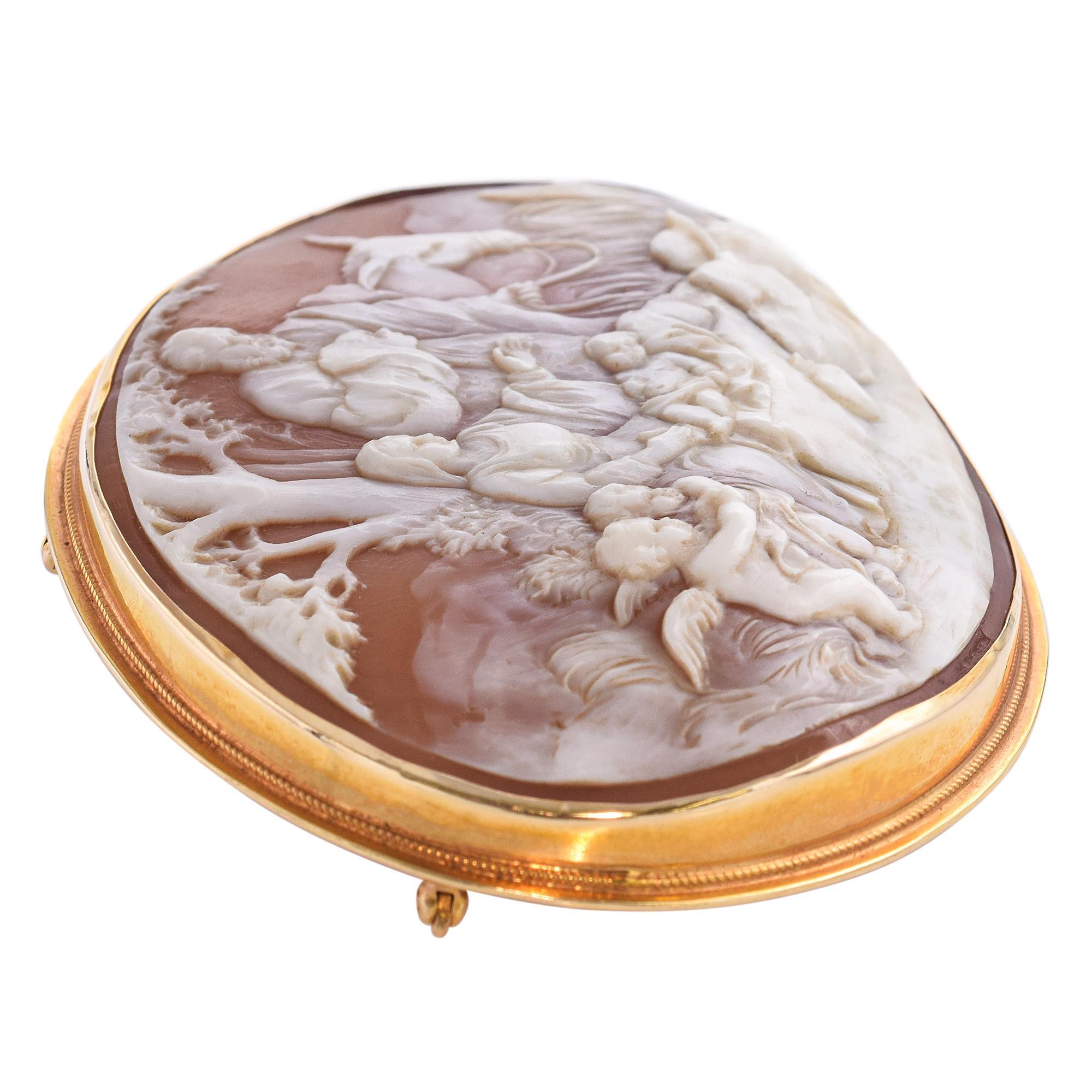 This antique brooch pendant, crafted in 13k yellow gold, features a masterfully carved shell cameo depicting the Nativity scene. The delicate rendering of 
