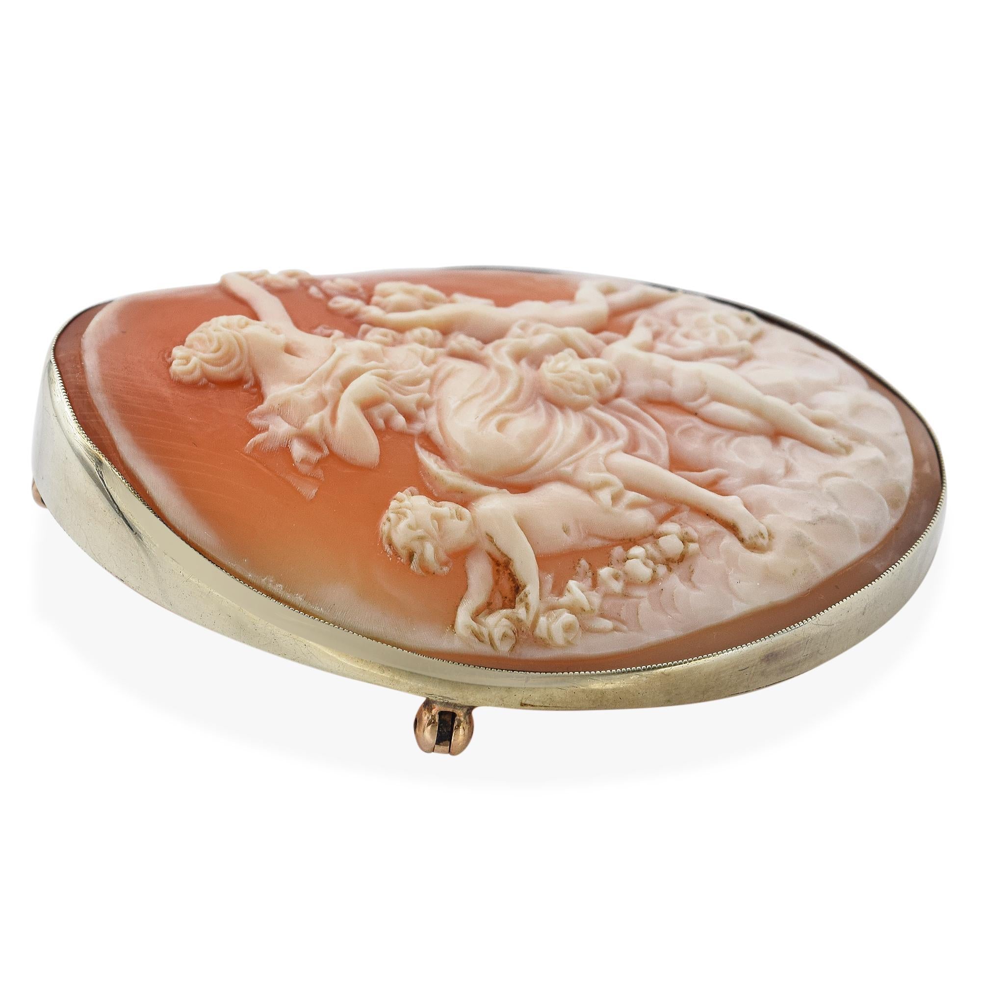 This enchanting antique brooch pendant showcases a beautifully carved shell cameo depicting Venus surrounded by playful cupids. Set in warm yellow gold, the scene captures classical elegance and romantic symbolism with remarkable detail. Designed to