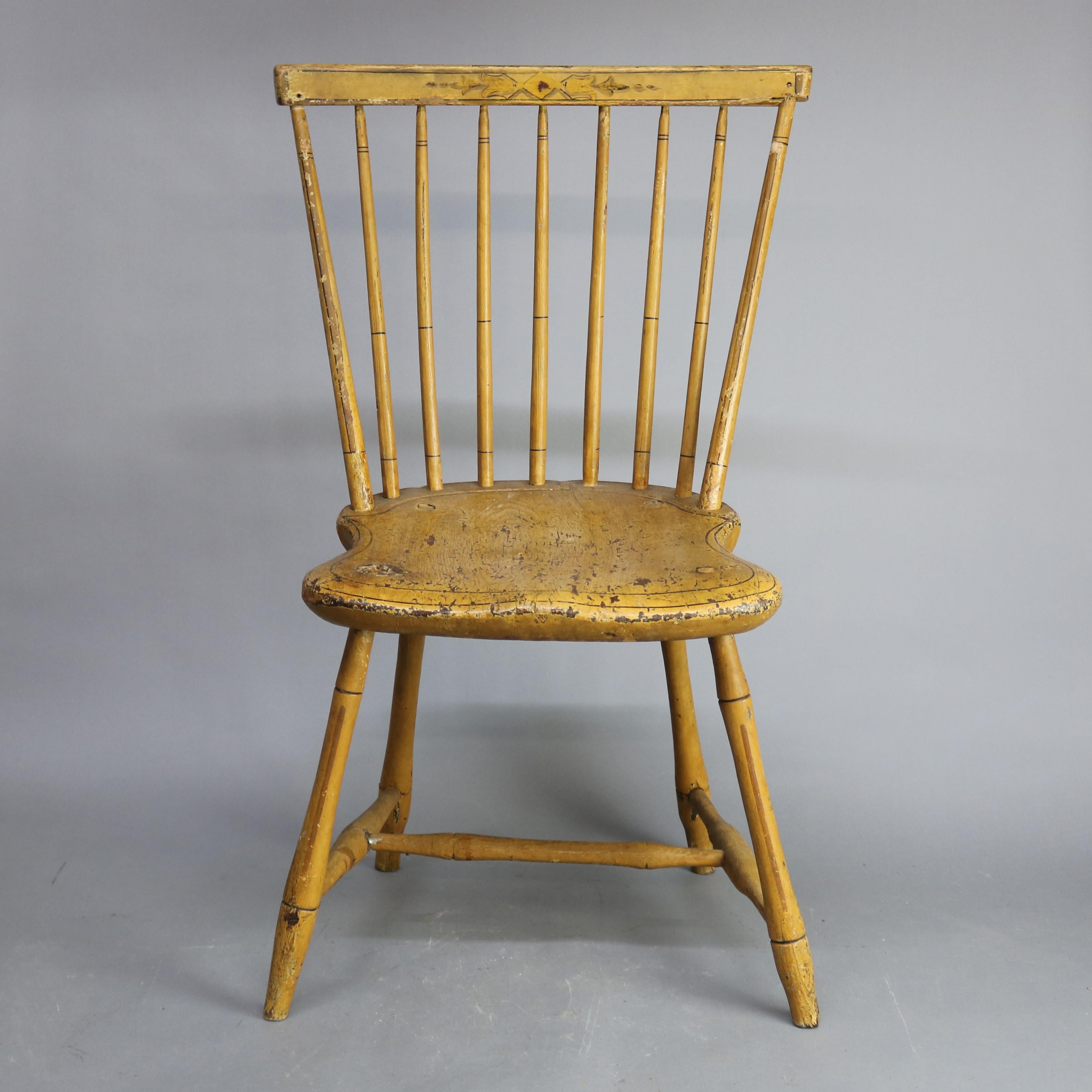 An antique paint decorated Windsor chair offers spindle back with stenciled crest and surmounting seat raised on turned legs, original mustard yellow paint, circa 1820.

Measures: 34