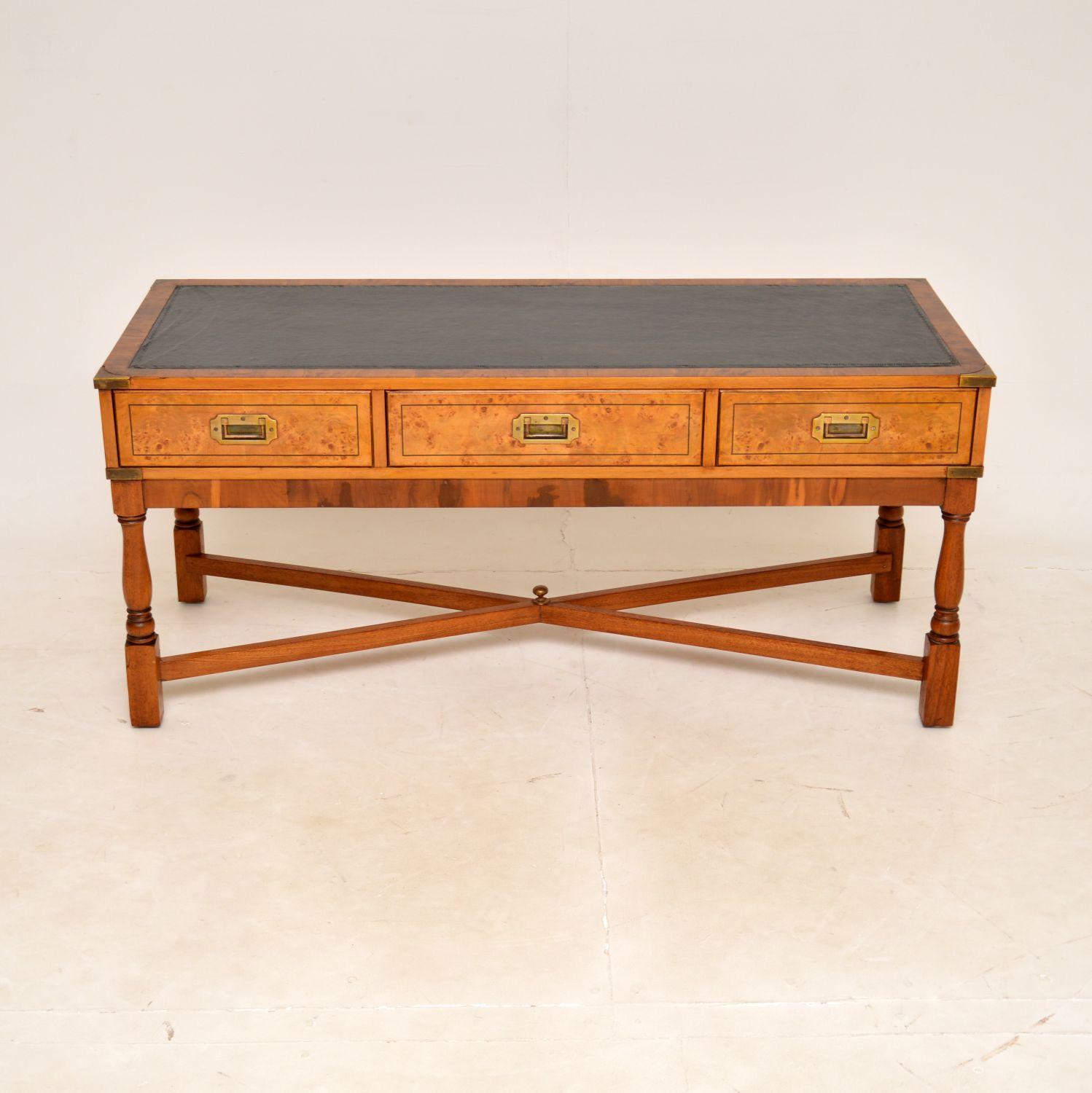 A smart and impressive antique leather top coffee table in the military campaign style. This was made in England, it dates from around the 1950’s.

It is a great size and is of amazing quality. It is predominantly yew wood, with burr walnut drawer