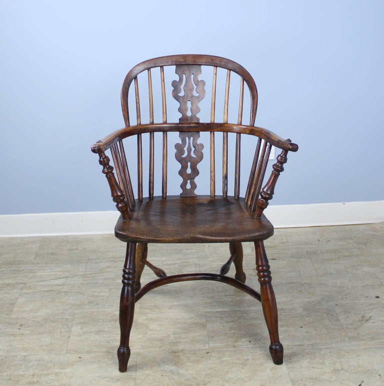 A classic Windsor chair, hand-carved in yew wood. Great color and patina, reflecting its use. Circular supports under the seat are charming.