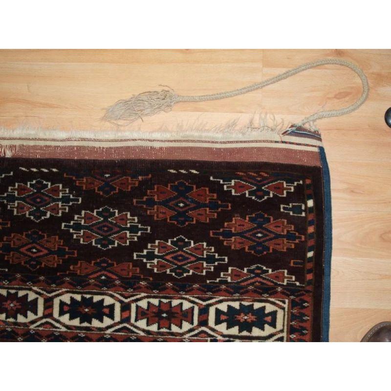 The carpet has a rich brown ground colour with some very nice blues and yellows. Note the original hanging cords that are attached at the top end of the carpet, it is rare to find these still attached.

The carpet is in excellent condition with