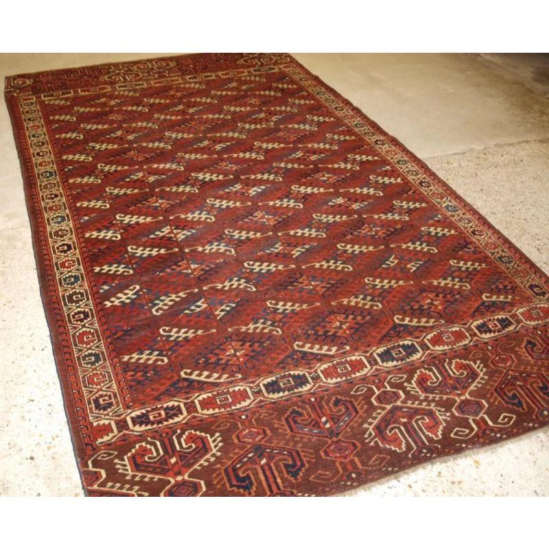 Antique Yomut Turkmen main carpet with the ‘Dyrnak’ gul design and superb large elem panels at both ends. The carpet has a rich brown ground colour with some very nice blues, greens, ivory and reds. The carpet has a well drawn curl leaf border. A