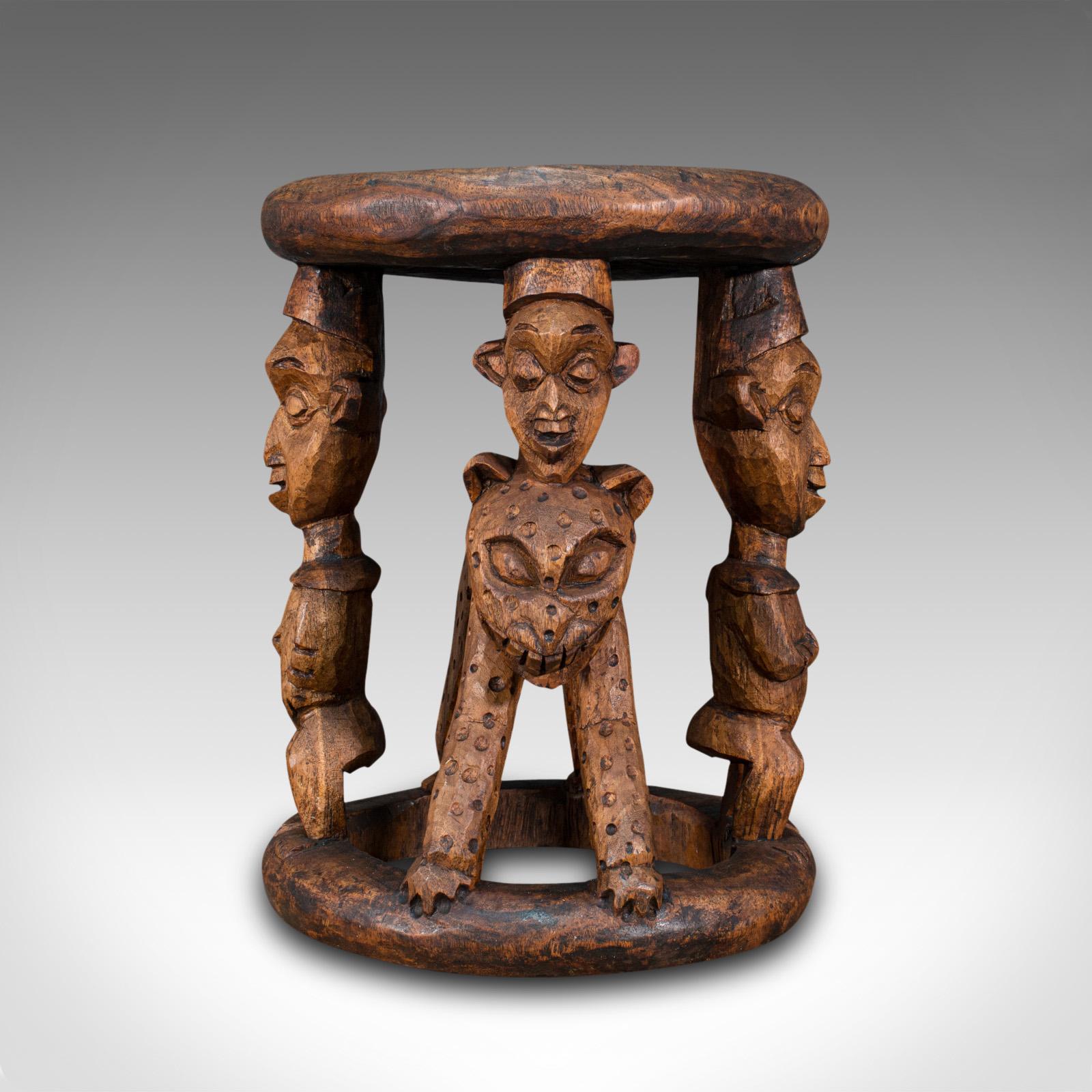 Dies ist ein antiker Yoruba-Häuptlingshocker. Eine westafrikanische Zeremoniallampe oder ein Beistelltisch aus Hartholz aus dem Königreich Benin, aus dem späten 19. Jahrhundert, um 1900.

Auffallendes Beispiel westafrikanischer Stammeskunst
Zeigt