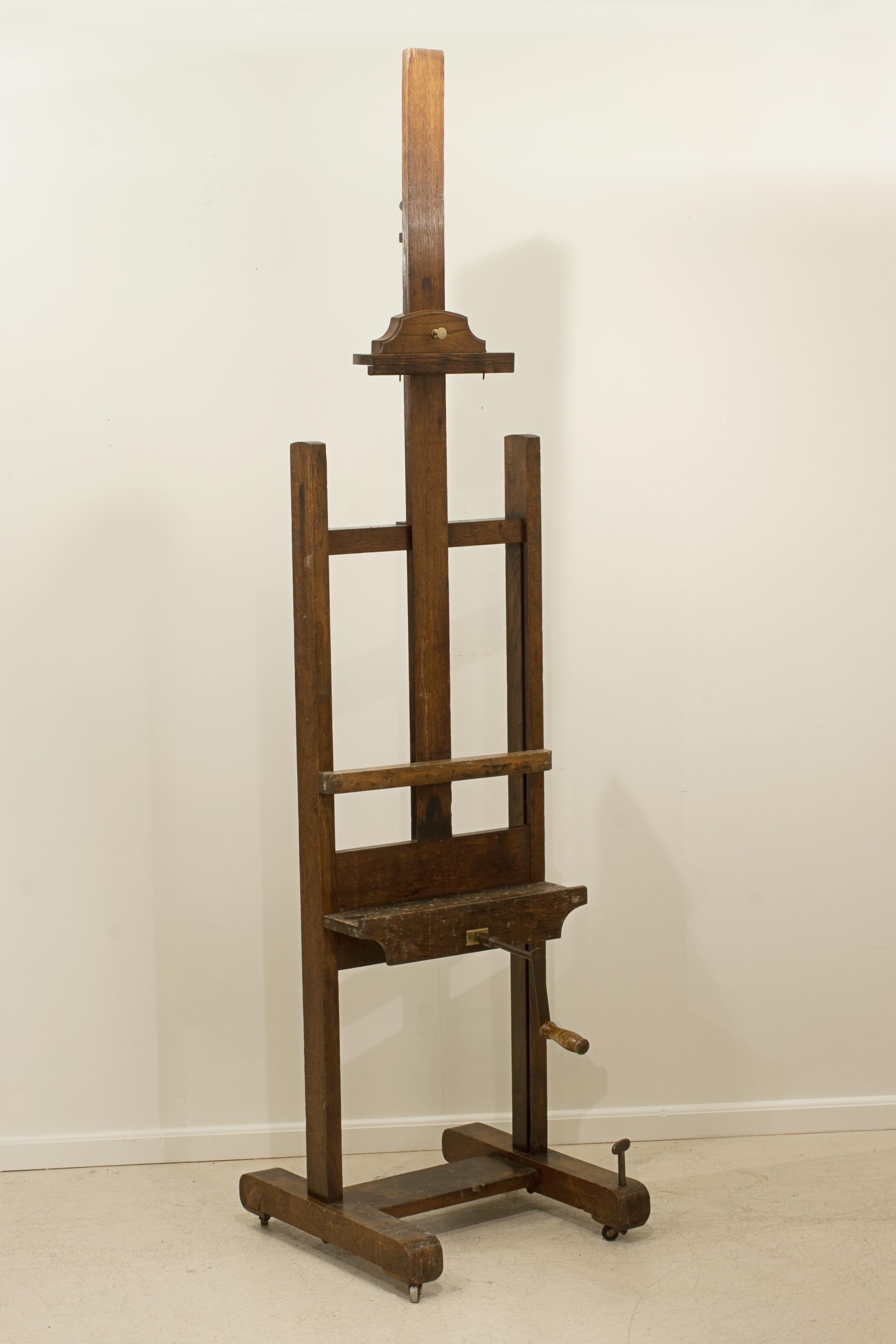 Vintage Young's Oak Artist's Easel.
An adjustable artist's studio easel raised up on a trestle base terminating in four casters, one castor is adjustable for levelling off. The painter's easel is made of solid oak with some oil paint remnants on the