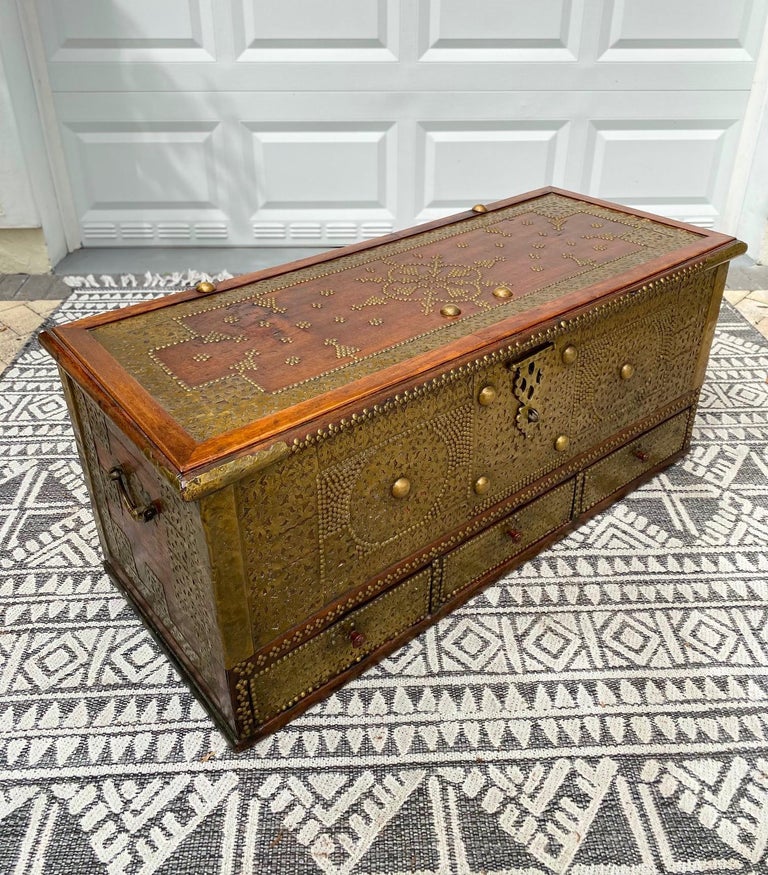 Rare 19th century handcrafted Zanzibar chest with brass metal overlay and brass mounts. The antique trunk is comprised of solid carved teak wood and features a hinged lid. The interior is fitted with a candle box on the upper right side. The chest