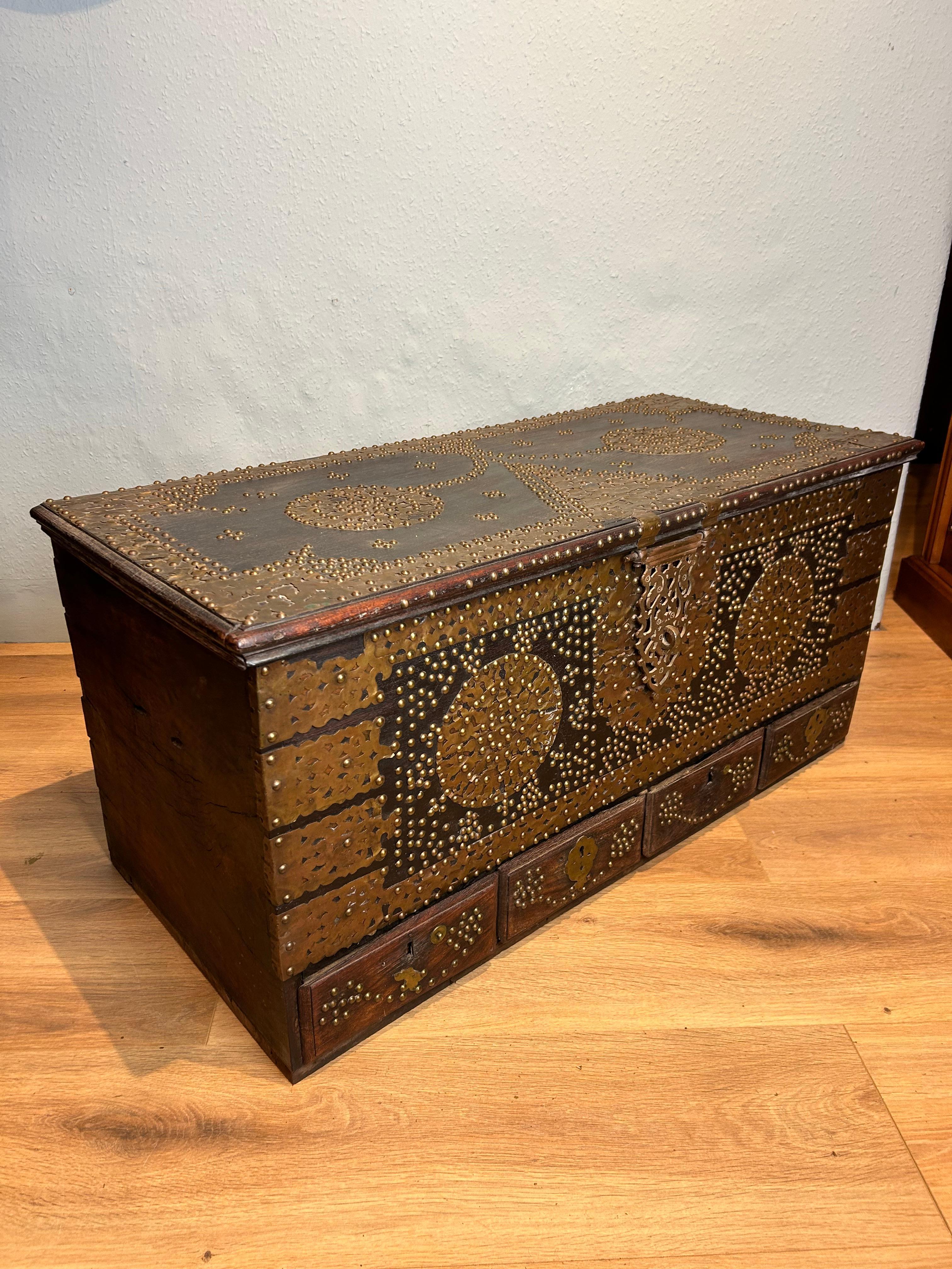 Stunning antique Zanzibar dowry chest, circa 1890. This useful chest can be used as a coffee table. Made of teak it has four drawers and three secret drawers. The chest is decoratively decorated  with brass overlay and studs.