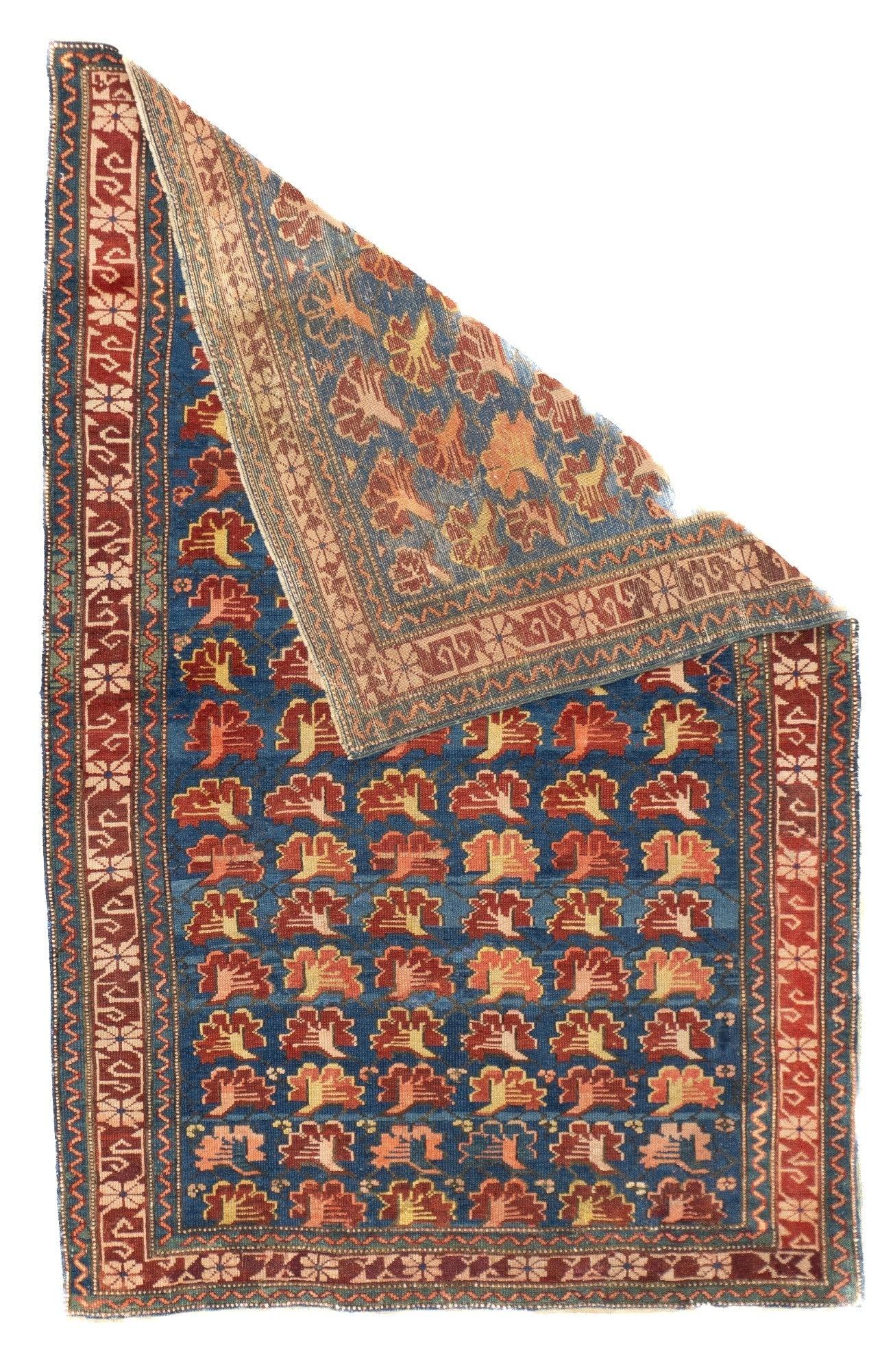 Alfombra Zehour Antigua 3'5'' x 5'2''. Cinco hileras invertidas de claveles de perfil detallados en rojo y crema decoran el campo azul real ligeramente desgastado de este esparcidor de lana con tintes naturales. Característico borde rojo de Zeychur