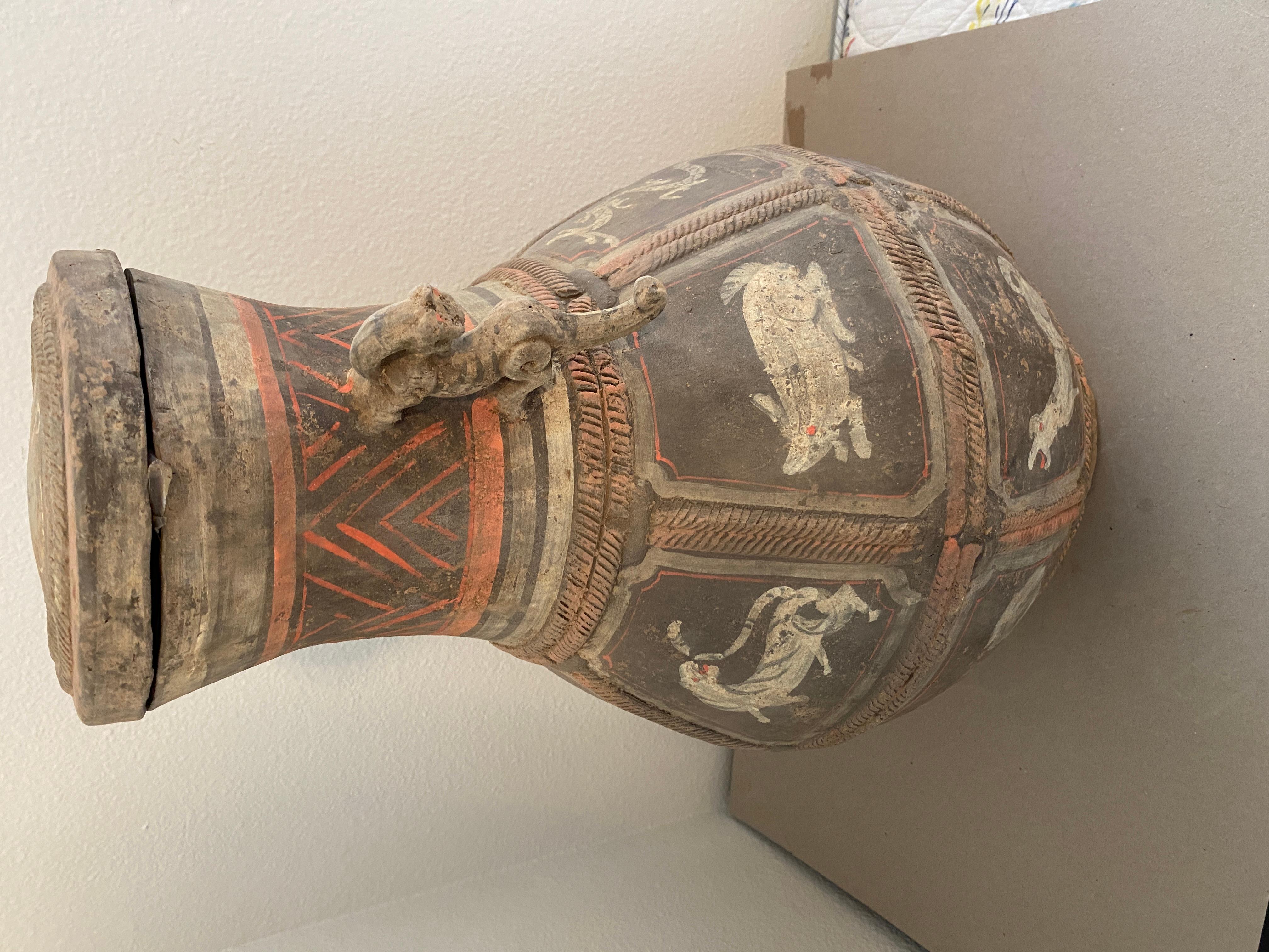 This Ahou Dynasty Funeral Vase will be a valuable addition to your collection.  It features delicately painted  animal characters and tiger handles.  It has a distinct look of antiquity.