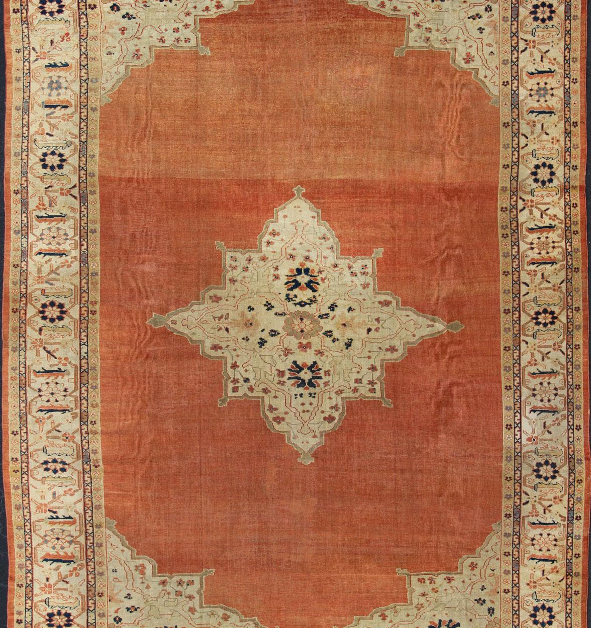 Large Antique Ziegler Sultanabad rug with central medallion in soft orange, ivory and pops of navy blue. Keivan Woven Arts / E-1207. Antique Ziegler, antique Persian Ziegler.
Measures: 10'2 x 14'5
This striking antique Ziegler Sultanabad carpet