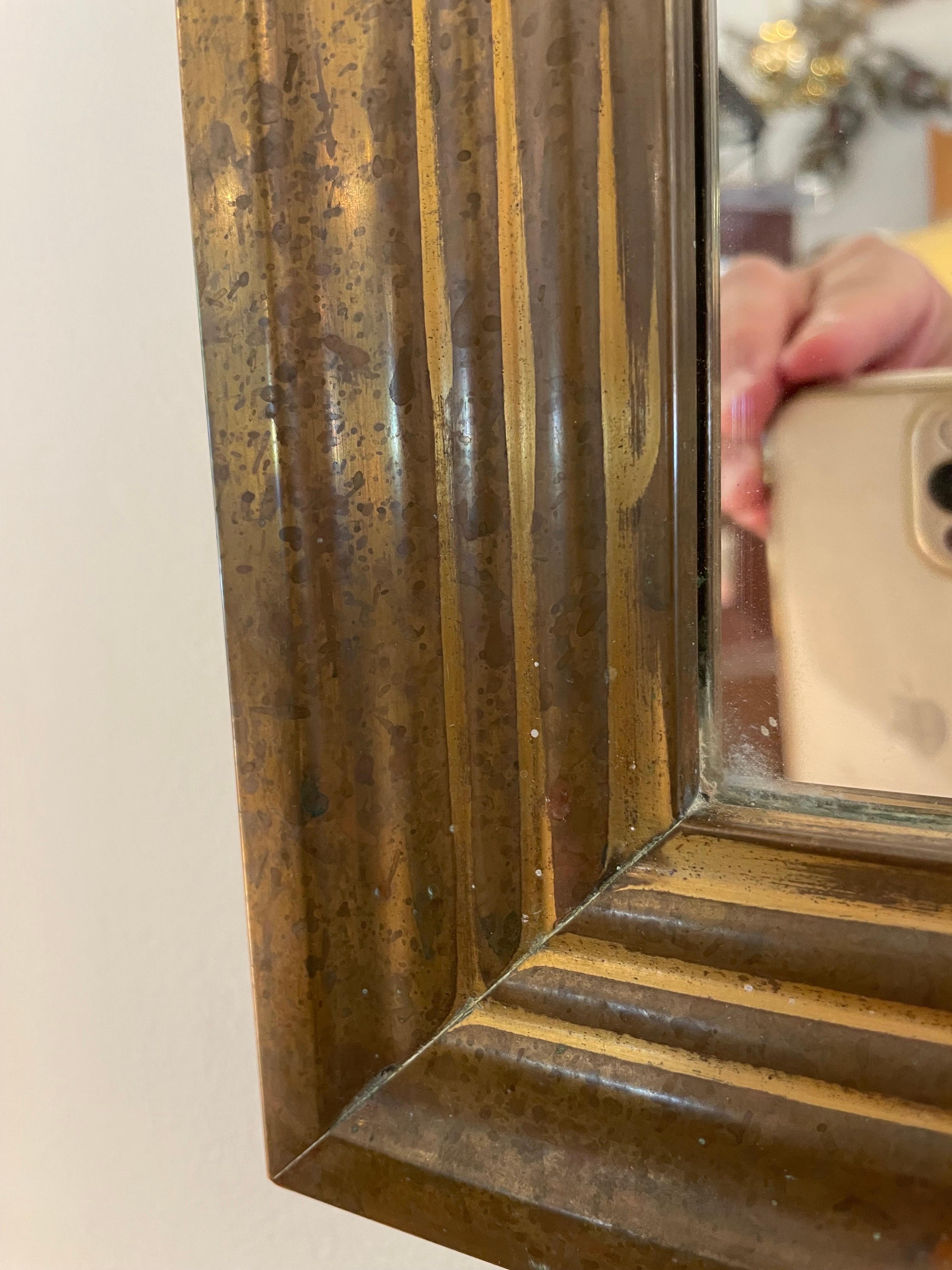Tiered and intricate molding style brass frame mirror from England. It has a wonderful patina which is age appropriate.  THIS ITEM IS LOCATED AND WILL SHIP FROM OUR EAST HAMPTON, NY SHOWROOM.