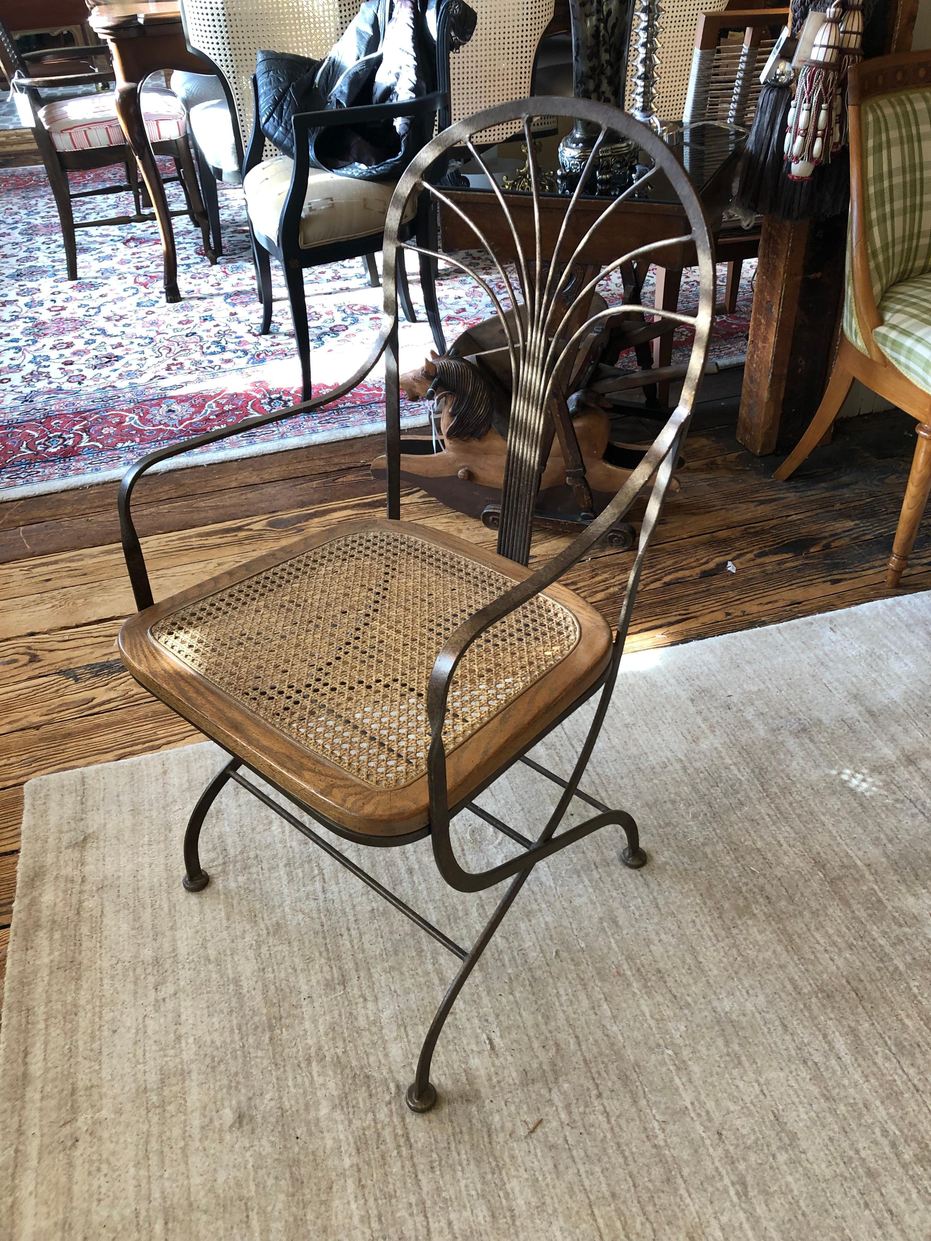 A great looking armchair or desk chair with an unusual earthy blend of warm bronze finish metal and wood surrounded cane seat. The chair is solid and comfortable with an airy look. The metal on the seat back suggests the branches of an abstract