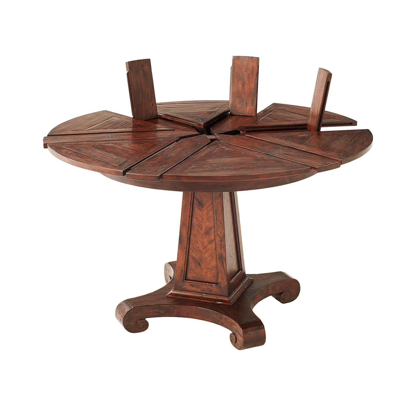 A small antiqued wood circular extending dining table, the top with pull out leaves and fold-out extenders, above a tapered column and a quatrefoil down scroll base. 

Dimensions: 47.25
