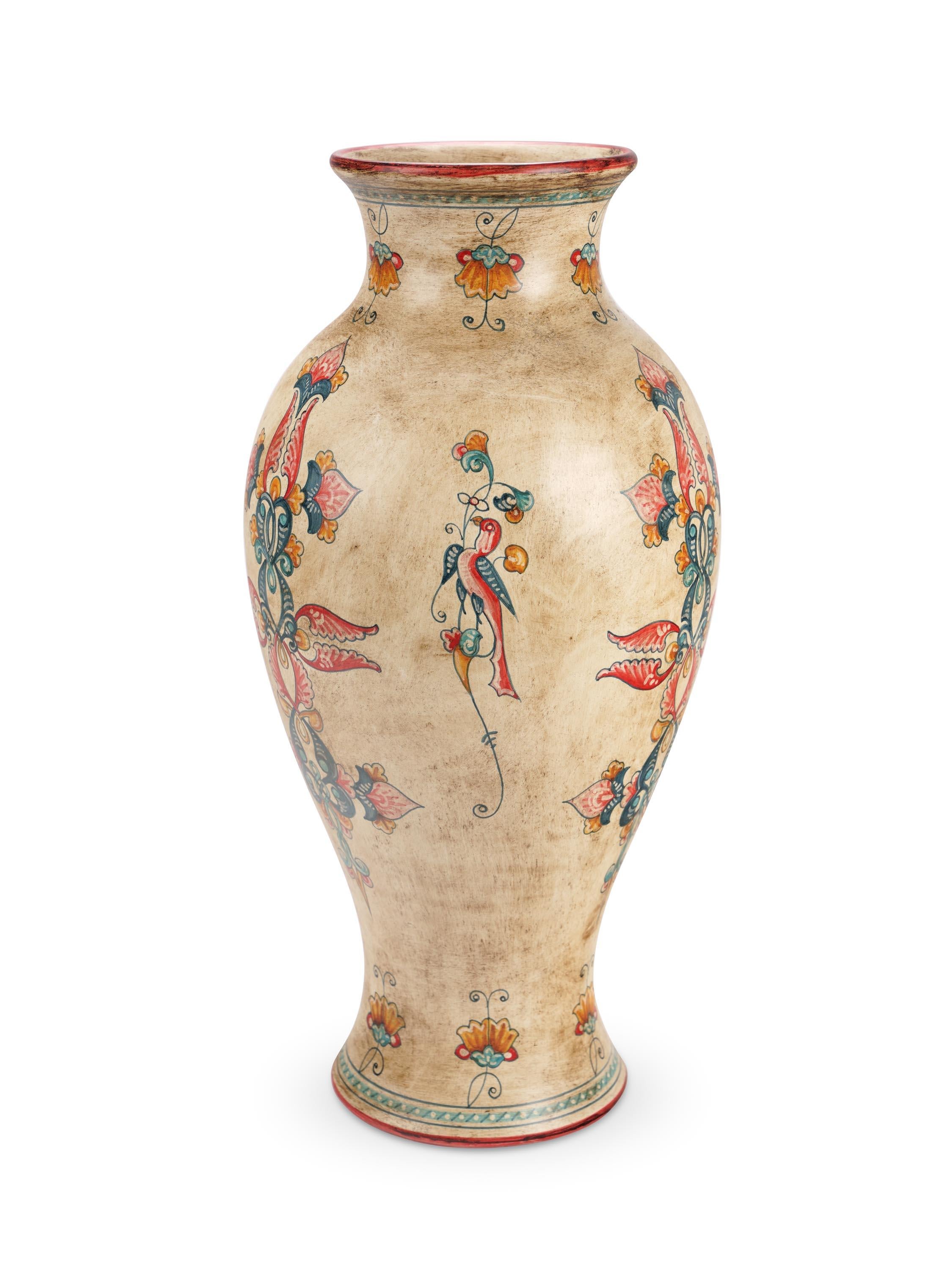Vase in majolica with antiqued background characterized by a very slender body, it is made and hand painted in Italy, following the original Renaissance painting technique. The pure line of the product is embellished with a decoration of floral