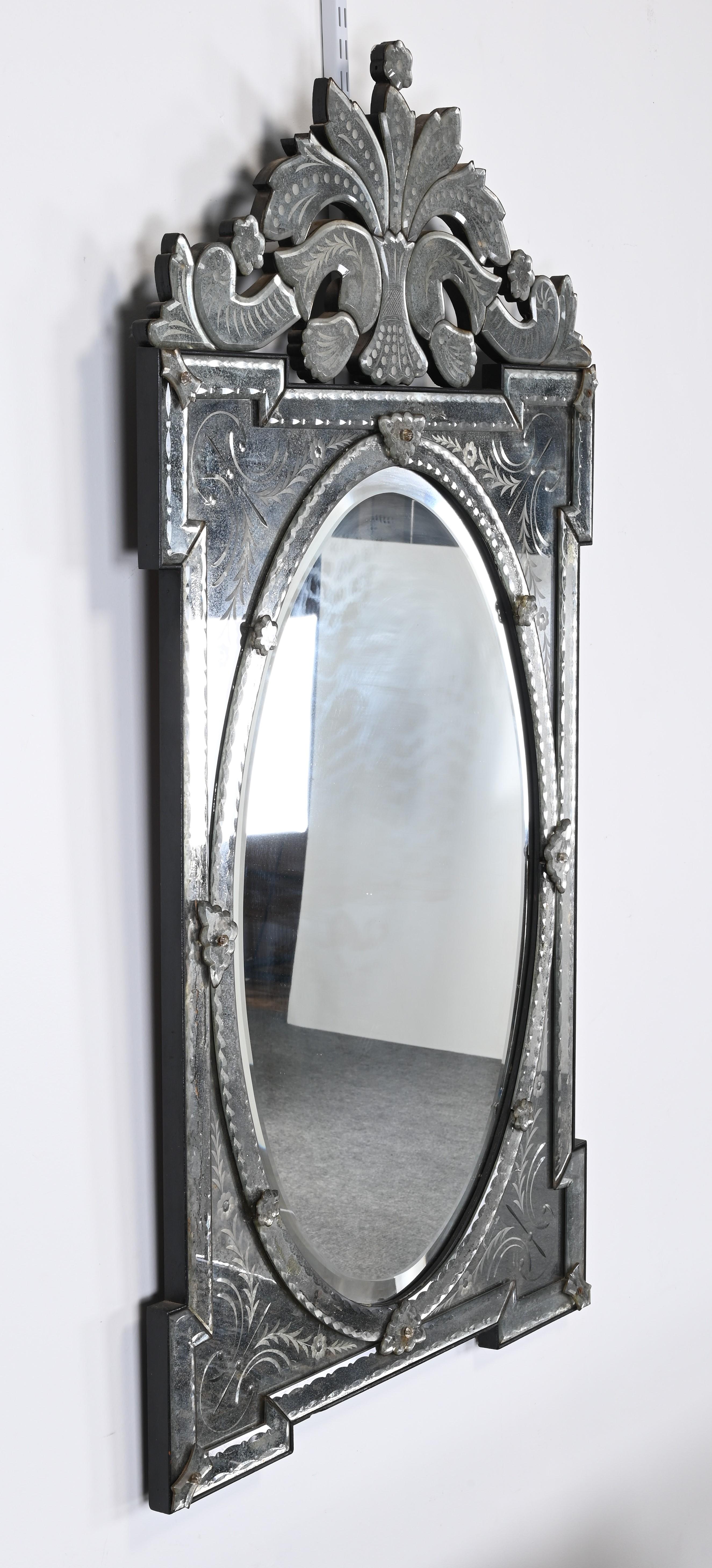 Magnifique miroir mural vénitien italien antiquisé et gravé, vers 1950-1960. Ce magnifique miroir vintage conviendrait parfaitement à un décor de style régence hollywoodienne, traditionnel ou même contemporain. Le miroir complexe est d'une grande
