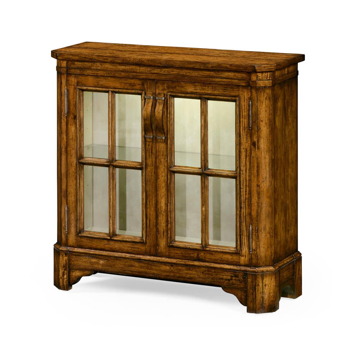 English country style antiqued walnut glazed low wall bookcase with internal lighting, two doors, and adjustable glass shelves. Wooden strap handles with patinated brass details.

Dimensions: 35 5/8