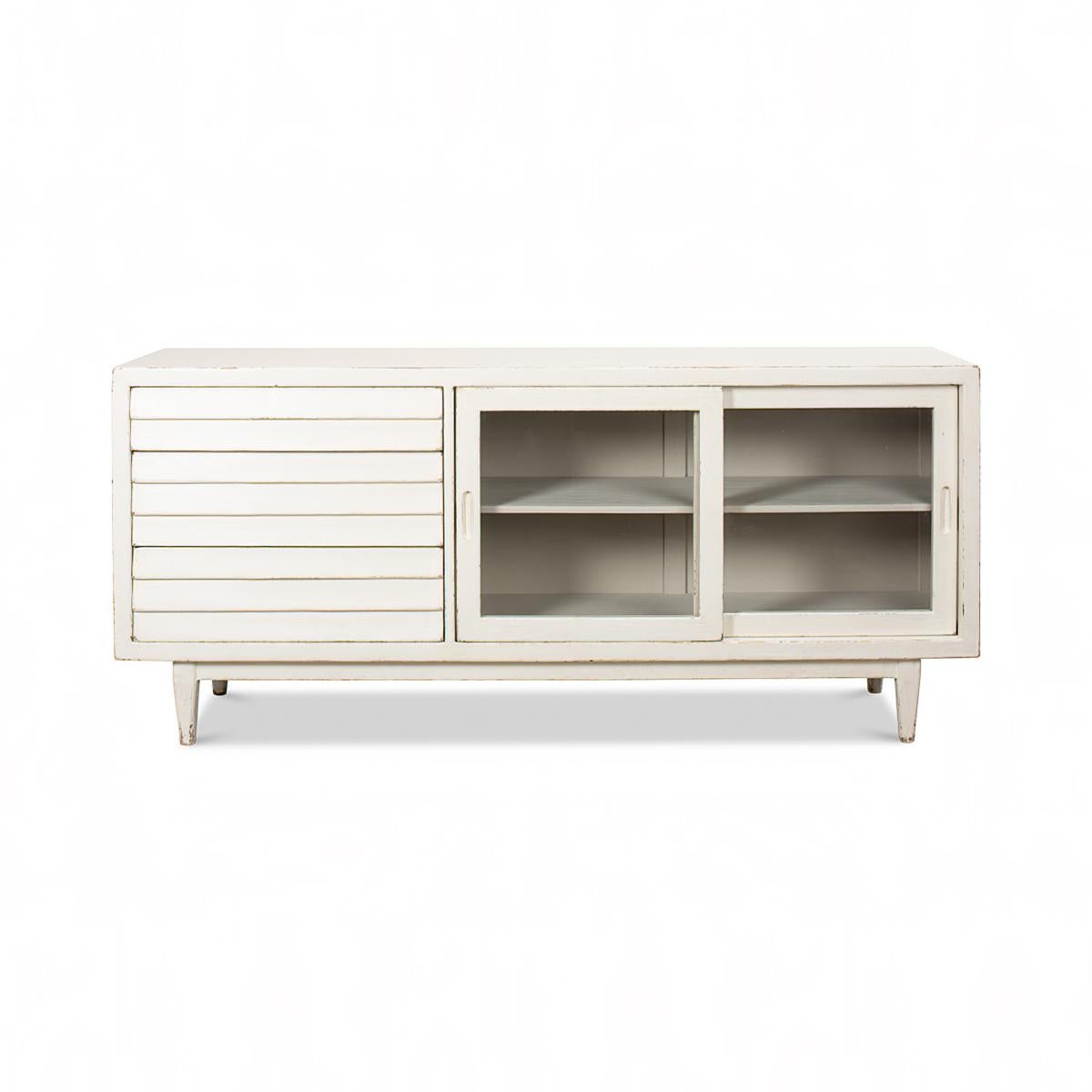 Antiqued White Painted Sideboard, made of pine in an antiqued white painted finish. With three graduated drawers, and two glass front sliding doors. 

Dimensions: 72