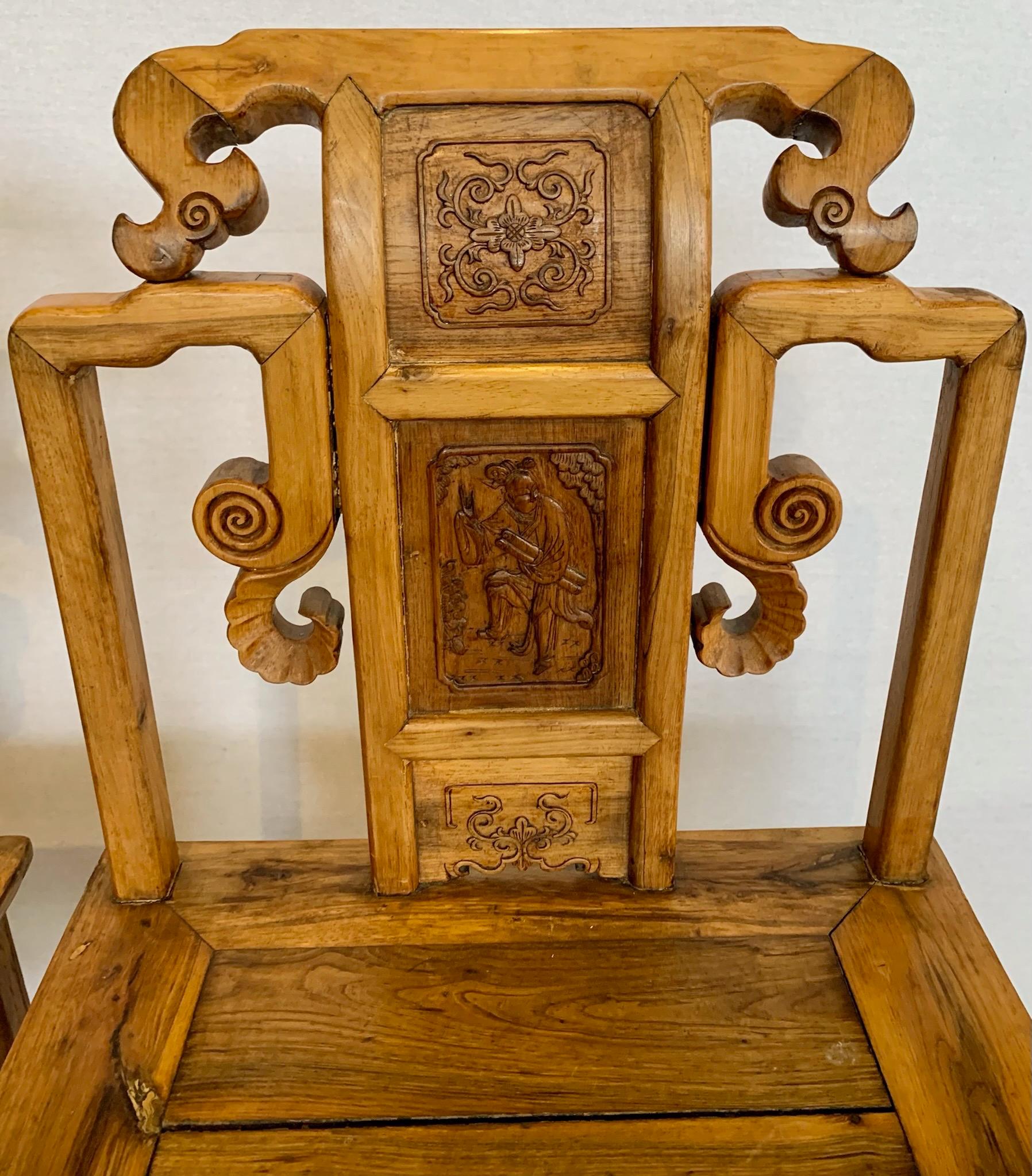 Near pair of antique Chinese side chairs with hand carved scrolled details with the back splat depicting Chinese scholars. Supported on square legs joined by stretchers.