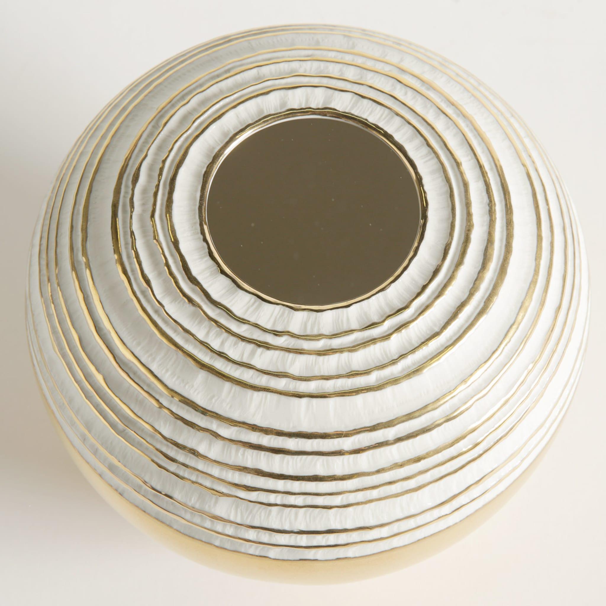 Dans ce vase en porcelaine exquis, un design classique est enrichi par la présence d'une précieuse couche externe d'or 23k appliquée à la main qui illumine le fond de la pièce et s'étend horizontalement en anneaux concentriques autour du sommet,