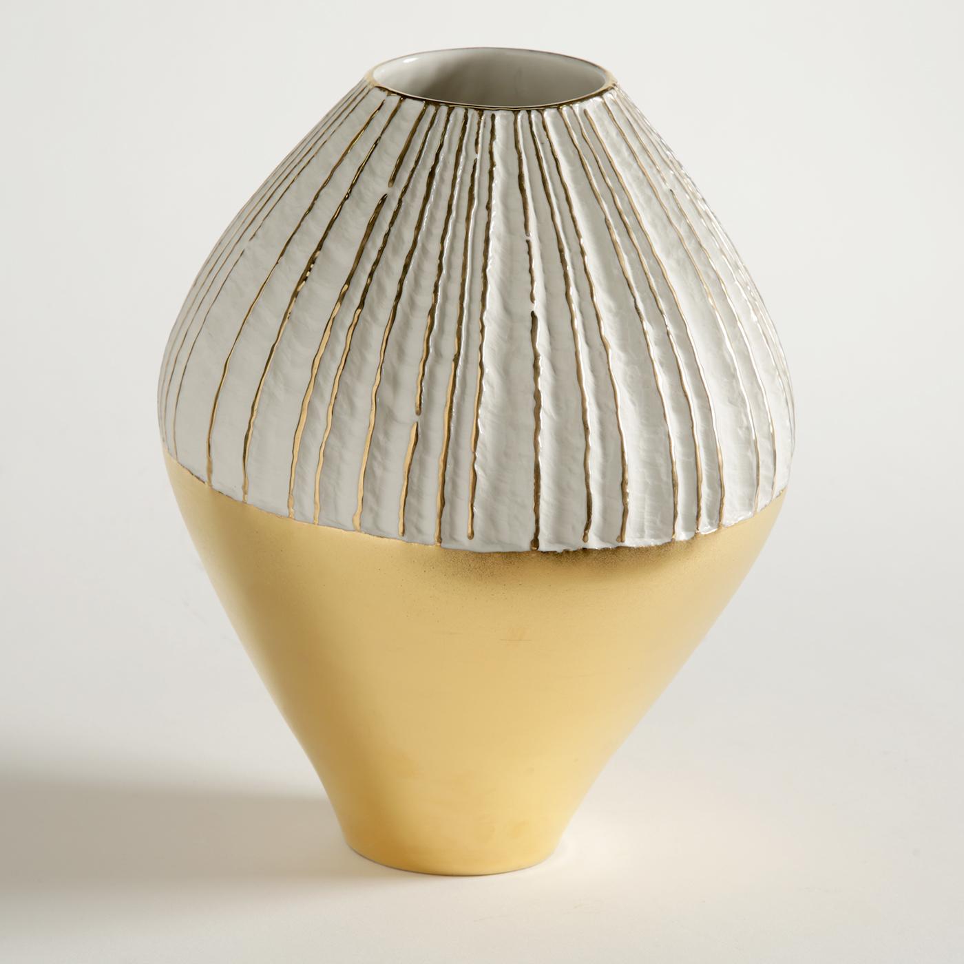 In this exquisite porcelain vase, a unique design is enriched by the presence of a precious external layer of hand-applied 23-karat gold that brightens the bottom of the piece and runs vertically in parallel lines around the top, making this vase a