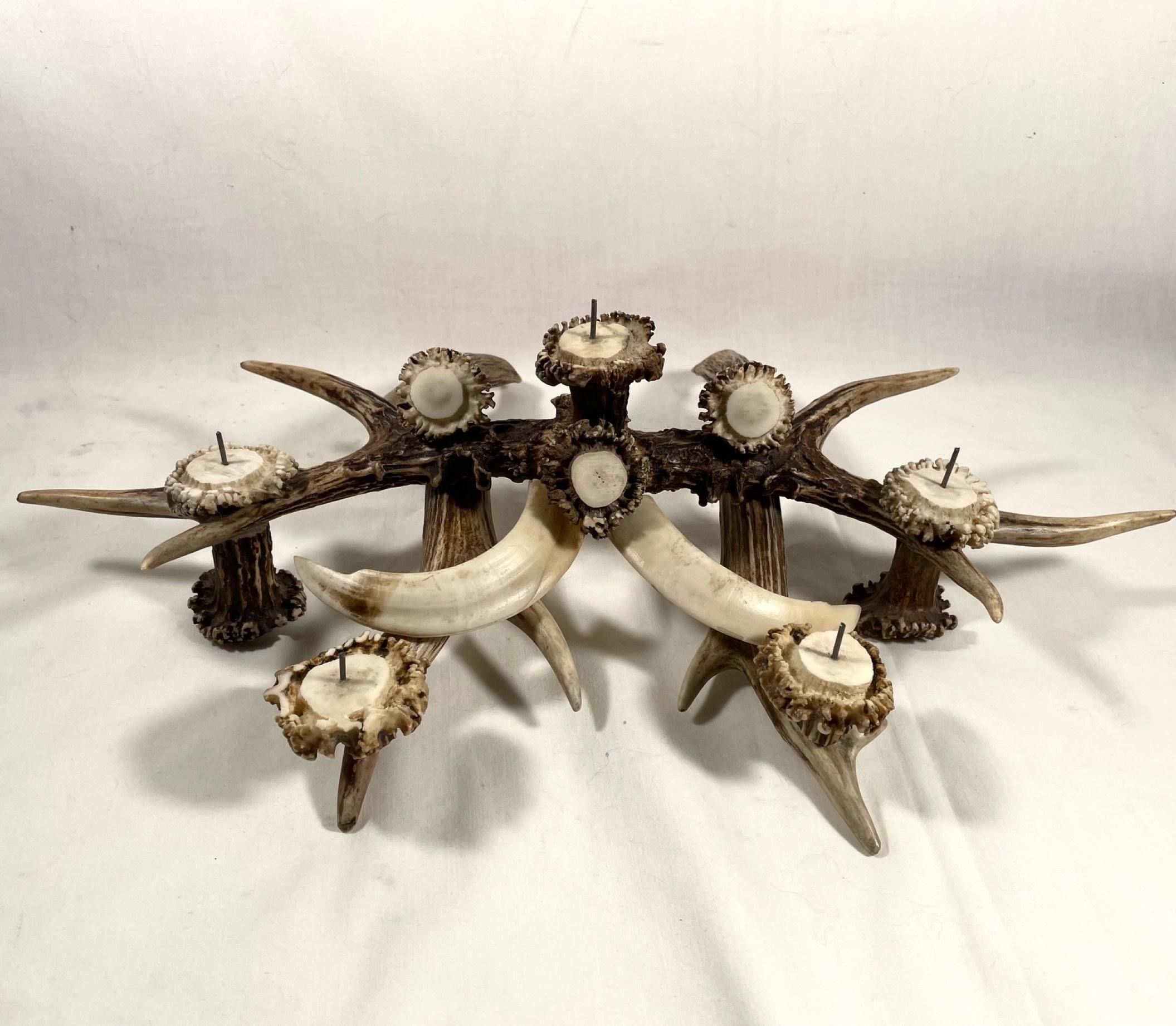 Antler and boar tusks candle holder centerpiece

This antique centerpiece candle holder is made of genuine deer antlers and Boar Tusks. It holds 5 candles. Cleverly mounted pieces result in a very decorative centerpiece ideal for a rustic