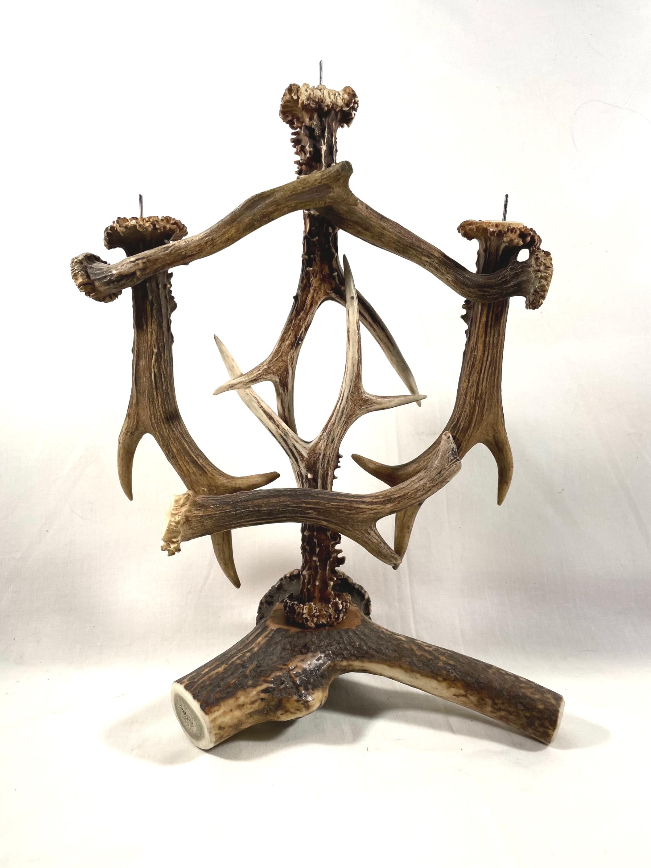 Antler candelabra, 3- armed with wood carved enzian flower medallion

This antique and one-of-a-kind candelabra candle holder is made of genuine deer antlers. Completely handmade and singularly designed, It holds 3 candles with metal prongs. A
