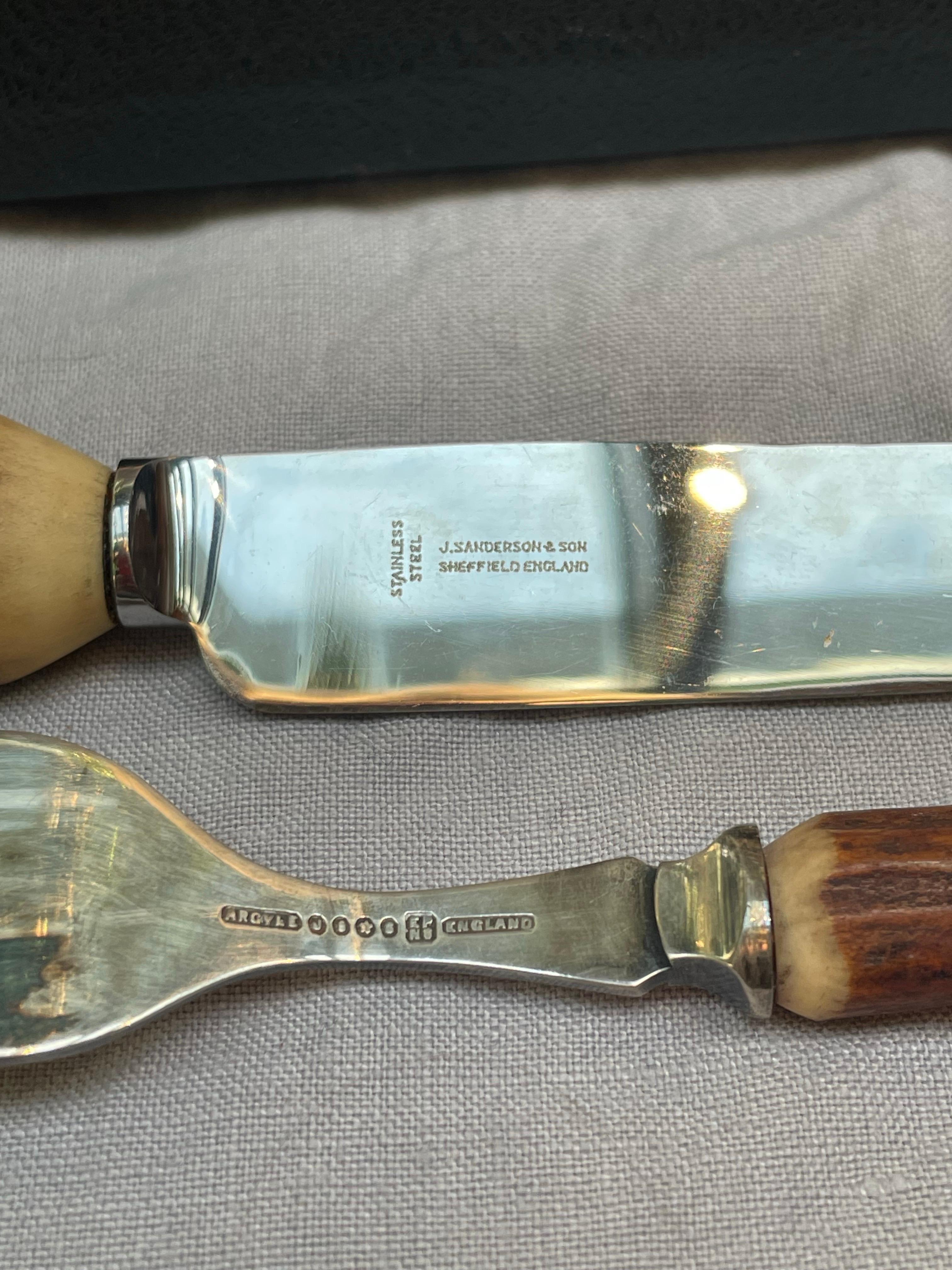 An elegant early 20th-century English antler-handled cutlery set by J. Sanderson & Son, Sheffield, England, renowned for their fine handcrafted tableware. This beautifully presented set comprises twelve pieces—six knives and six forks—housed in the