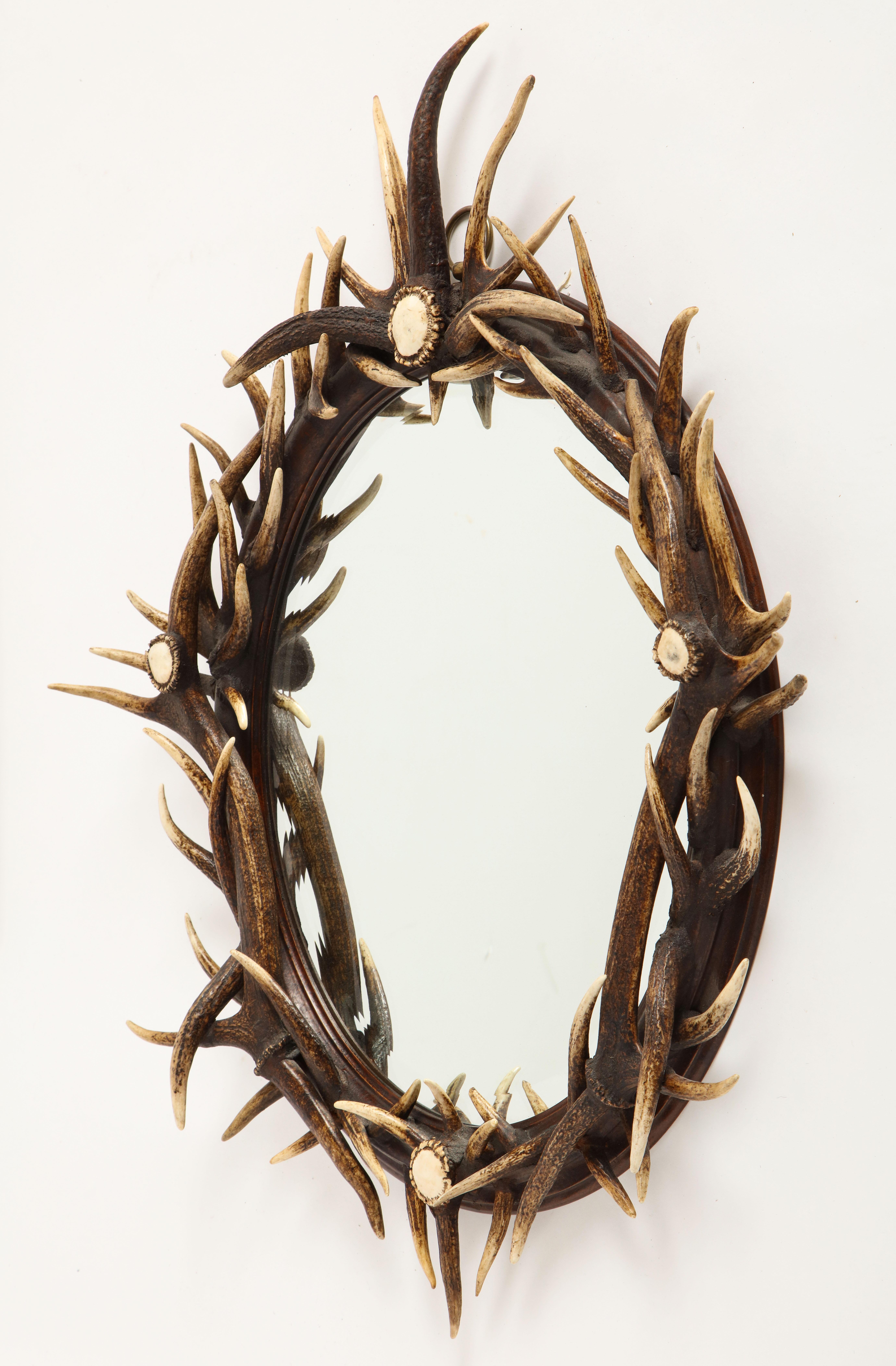 Antler-mounted mirror, 20th century. The circular molded frame mounted with antlers.

In overall good decorative condition. With general overall marks, nicks, surface scratches and tiny losses, as to be expected. With rubbing and minor cracks to