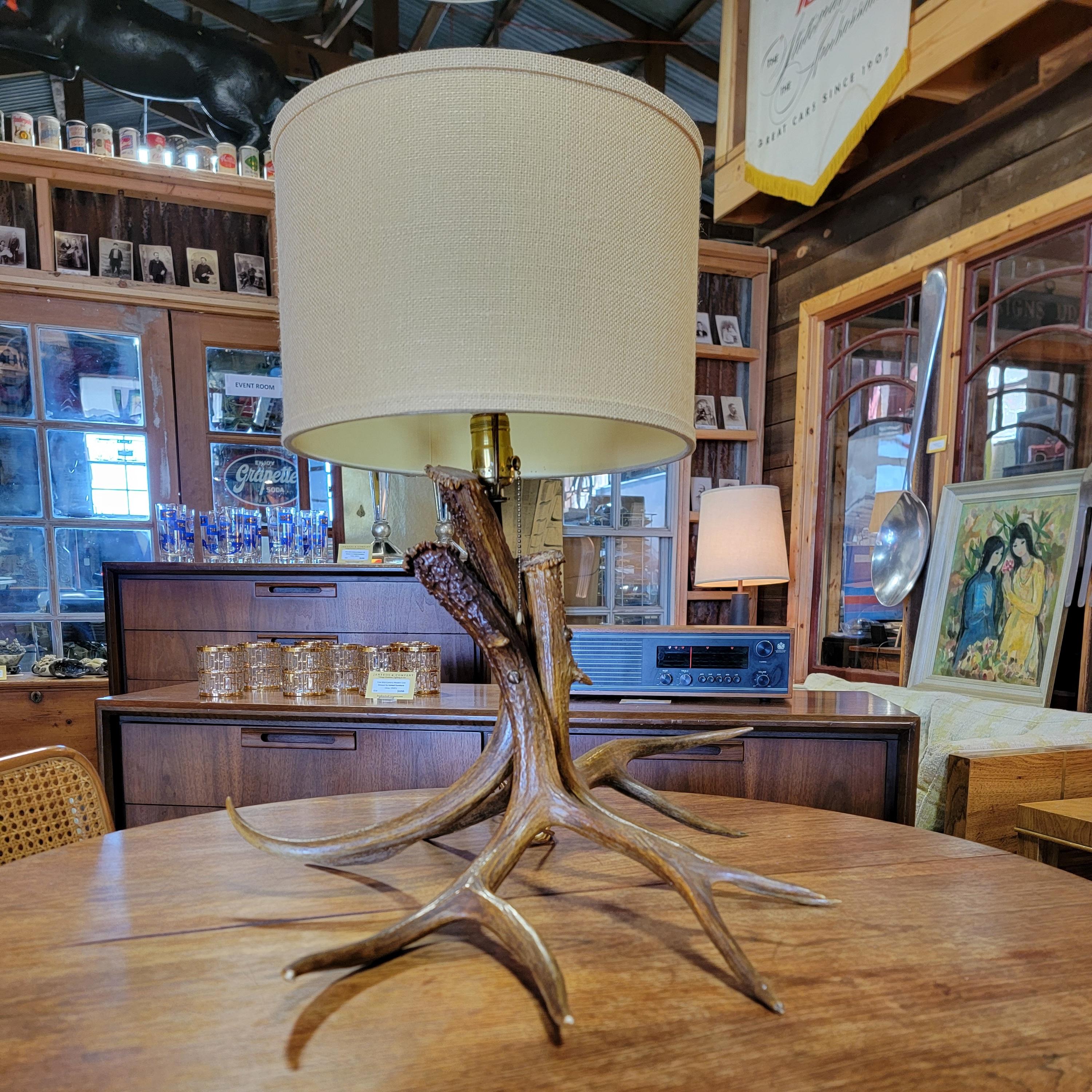 A 1950's deer antler table lamp. Consists of 3 antlers. Vintage shade included.
