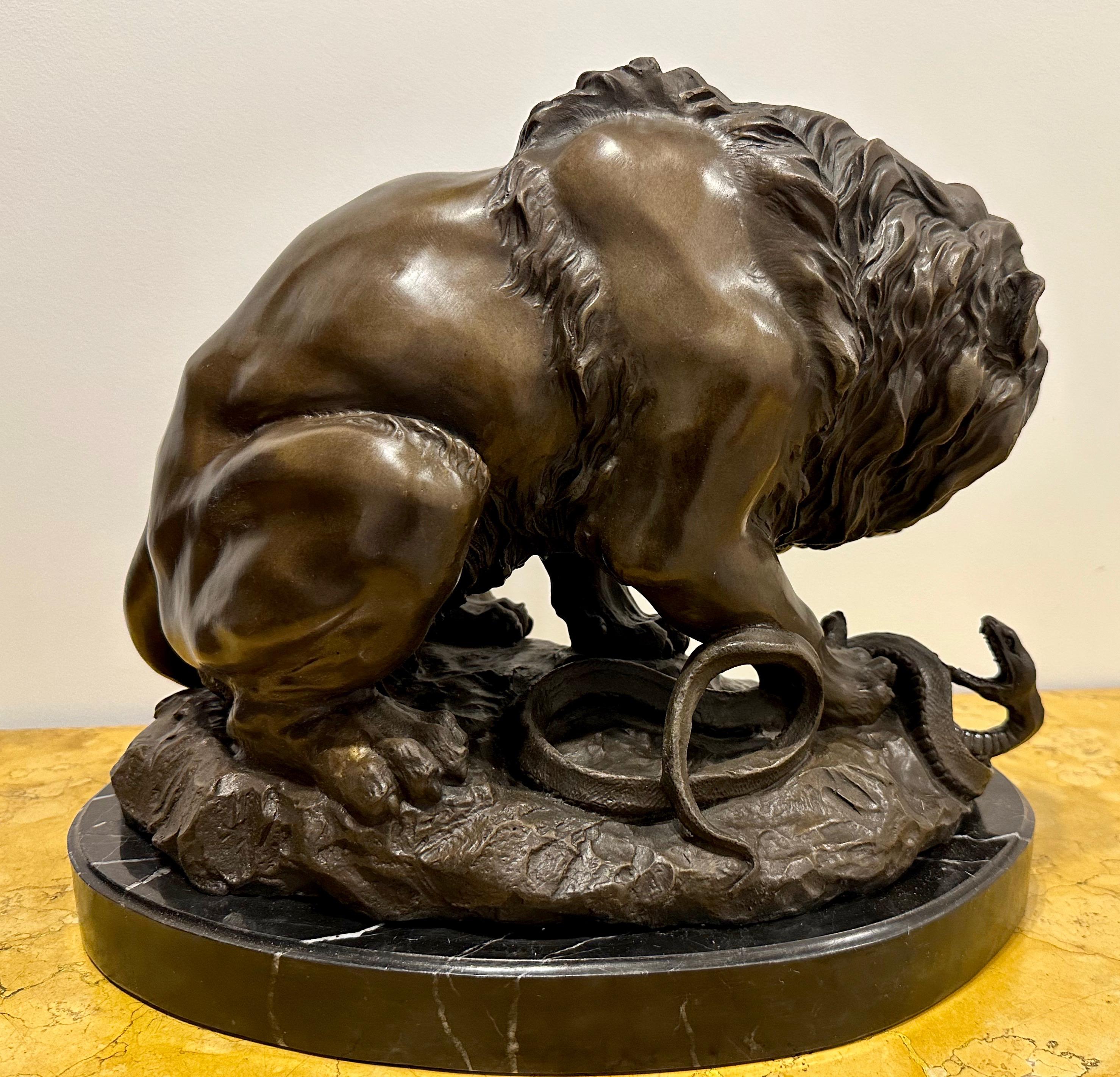 Français Bronze signé Antoine-Louis Barye (1795-1875) représentant un lion arrachant un serpent, vers 1870 en vente