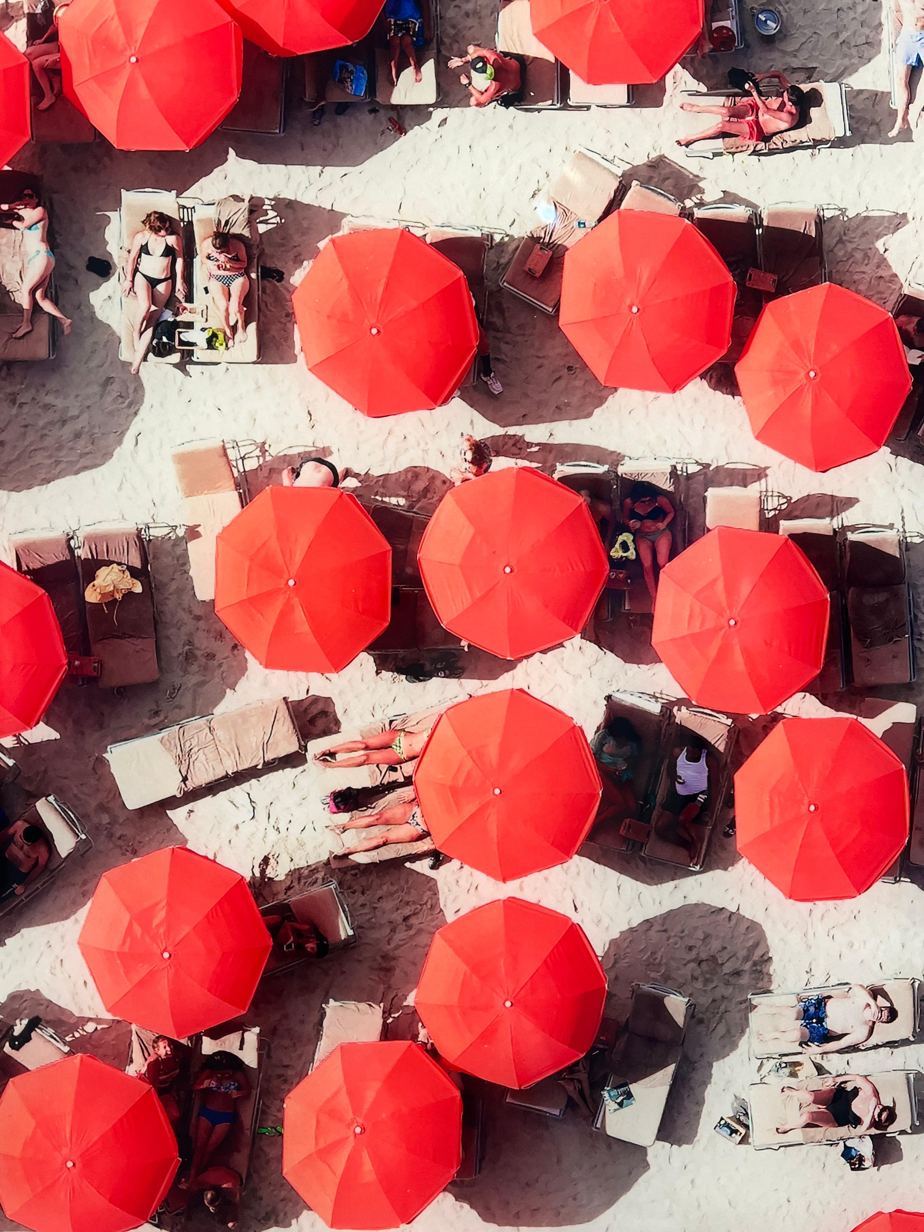 By hanging out of a helicopter hovering 300 feet in the air, Antoine Rose uniquely captures the Hamptons from a sharp 90 degree angle. This piece is a snapshot of shared beach activities that features colorful accessories and gorgeous blue-green