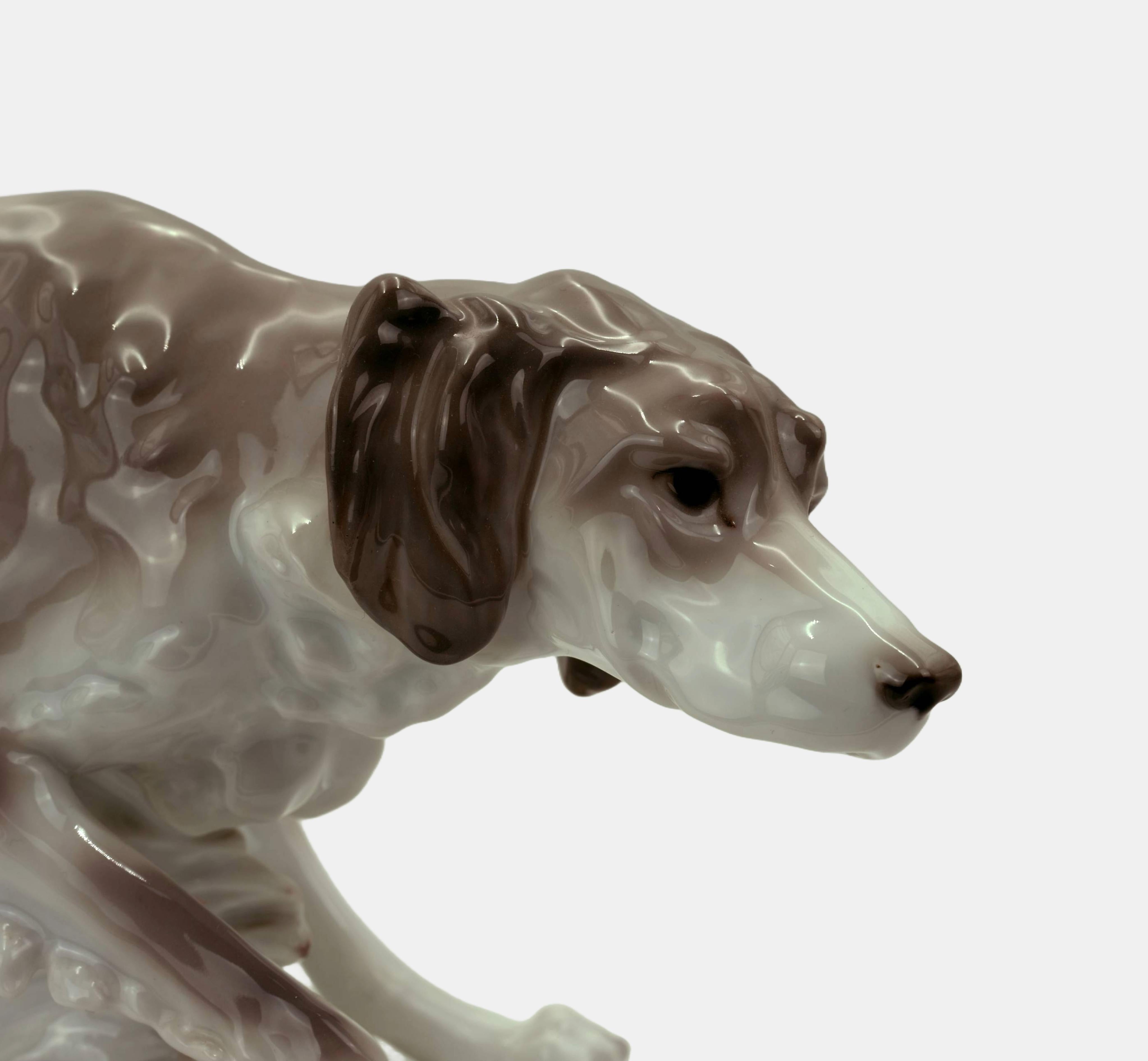 Anton Büschelberger (1869 Eger - 1934 Dresden), Pointer, around 1930, made by the Karl Ens porcelain manufactory in Volkstedt (Thuringia), model number 2478, 6. Porcelain with underglaze decoration and terrain plinth. 17 cm (height) x 37 cm (length)