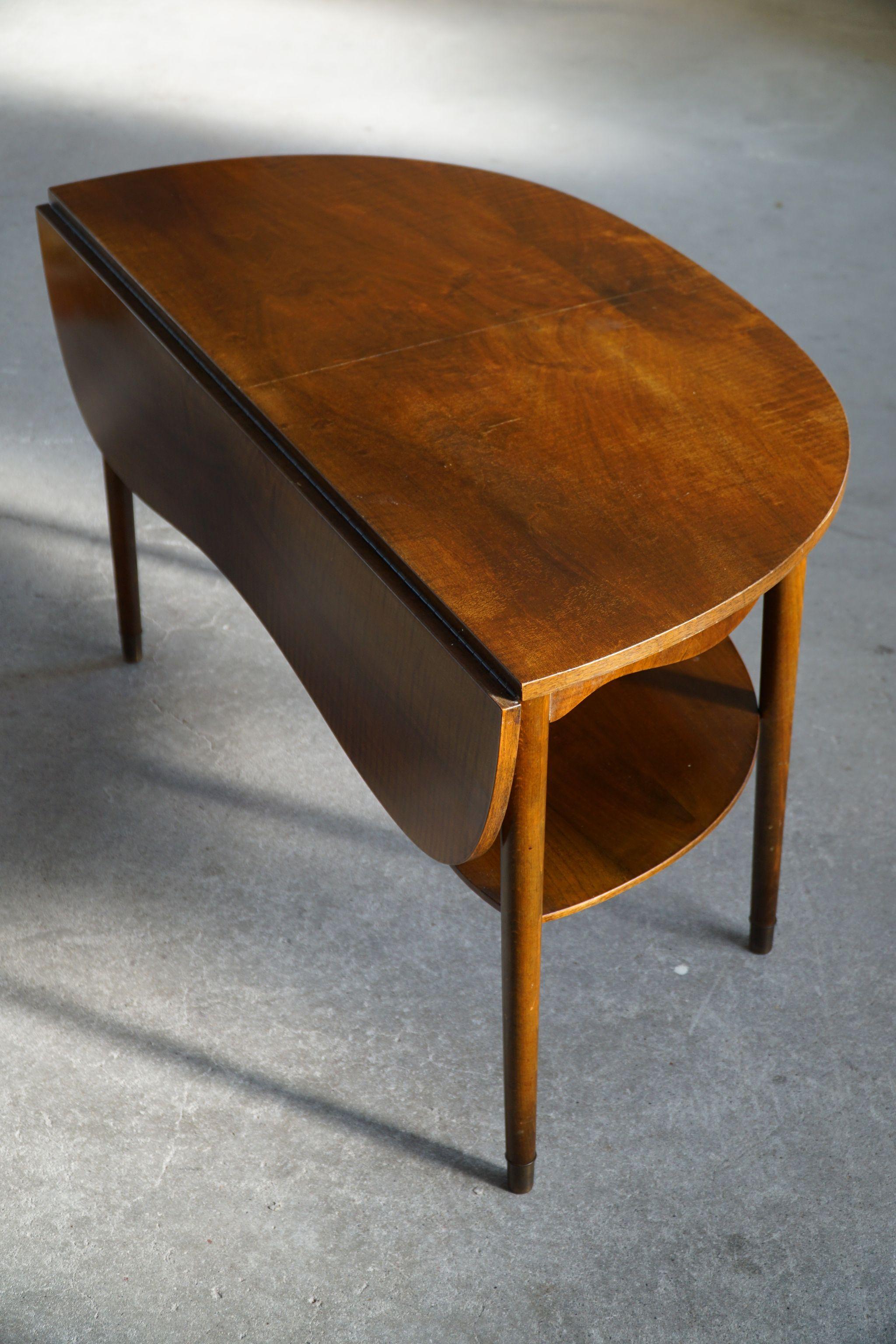A classic Danish drop leaf coffee table in walnut with brass shoes. Made by designer Anton Kildeberg for Anton Kildeberg Furniture in 1960s.

This piece is in a great vintage condition.

With a heavy focus on functionality, this design style