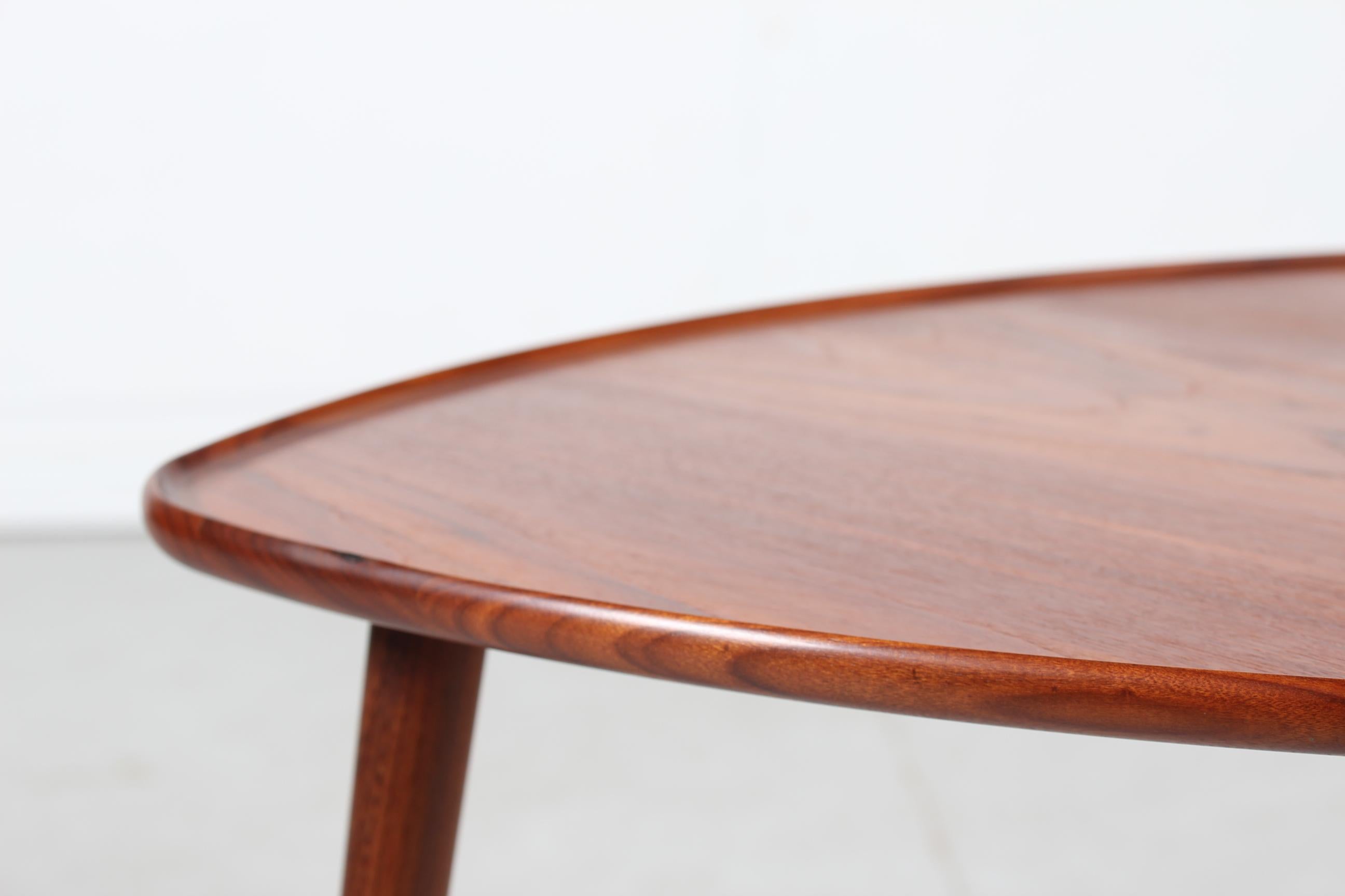 Anton Kildeberg organically shaped coffee table manufactured by Odense Møbelfabrik in 1968.
The table has a beautiful shape with a raised rim along the sides. It is made of solid teak and teak veneer with oil treatment. The legs are round and