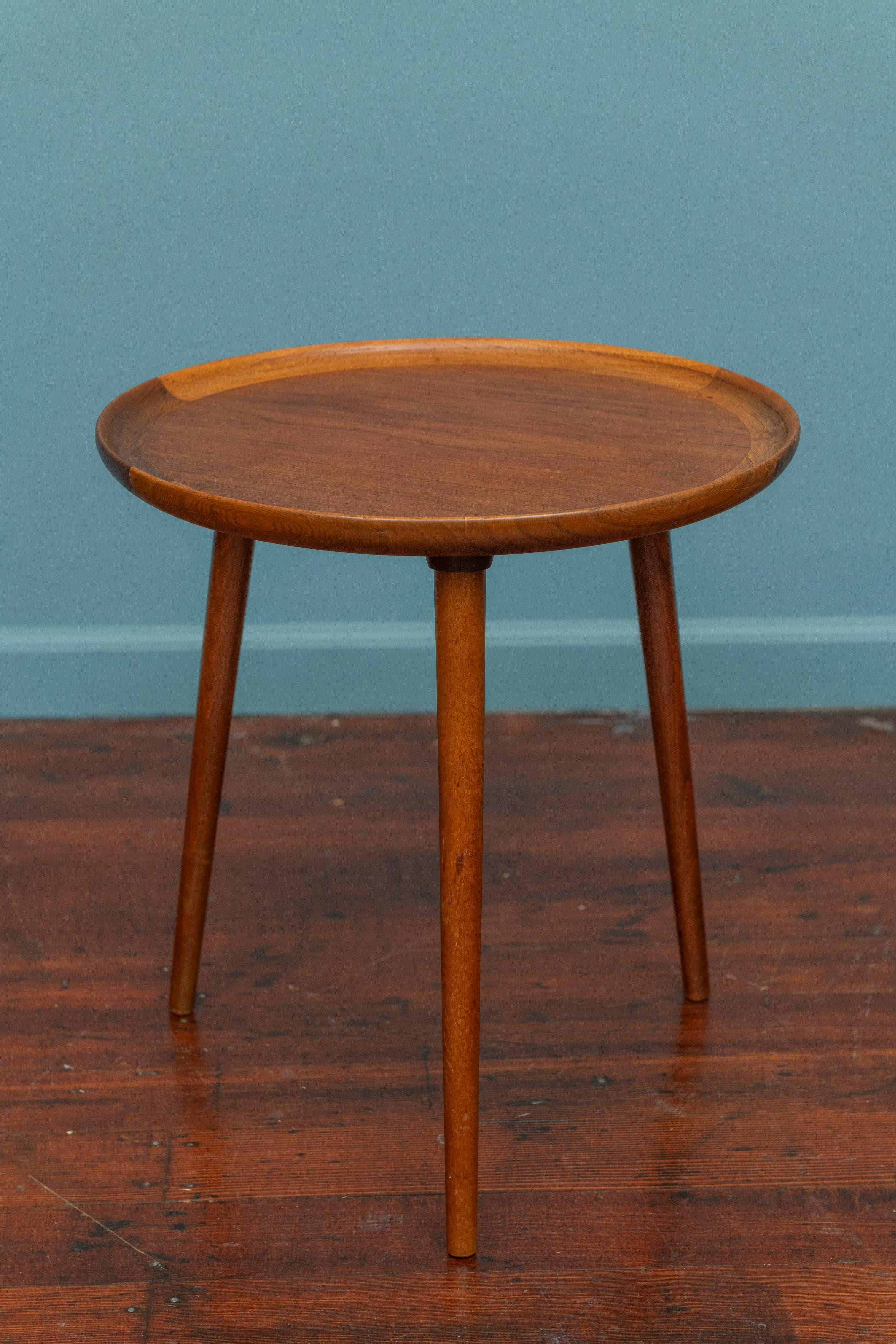 Scandinavian Modern design side table by Anton Kildeberg, Denmark. Wonderful tripod base circular side table great for anywhere. Featuring high quality craftsmanship with a turned lip or gallery edge on three tabpering splayed legs. Ready to be