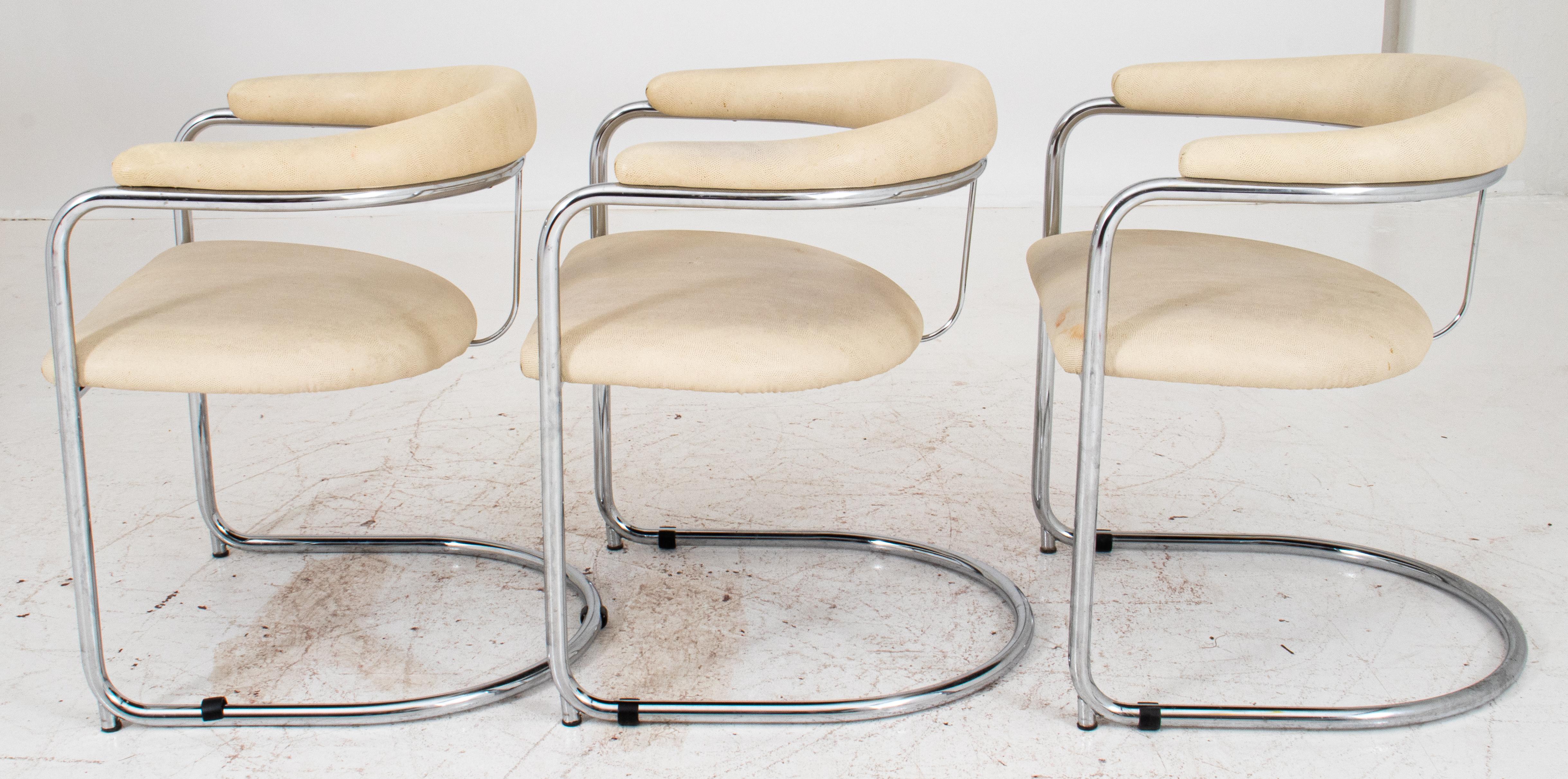 Three Anton Lorenz for Thonet cantilevered steel tube SS33 armchairs (designed ca. 1930), the curving back and conforming seat with chrome frames, upholstered in cream-colored snakeskin-stamped leather.