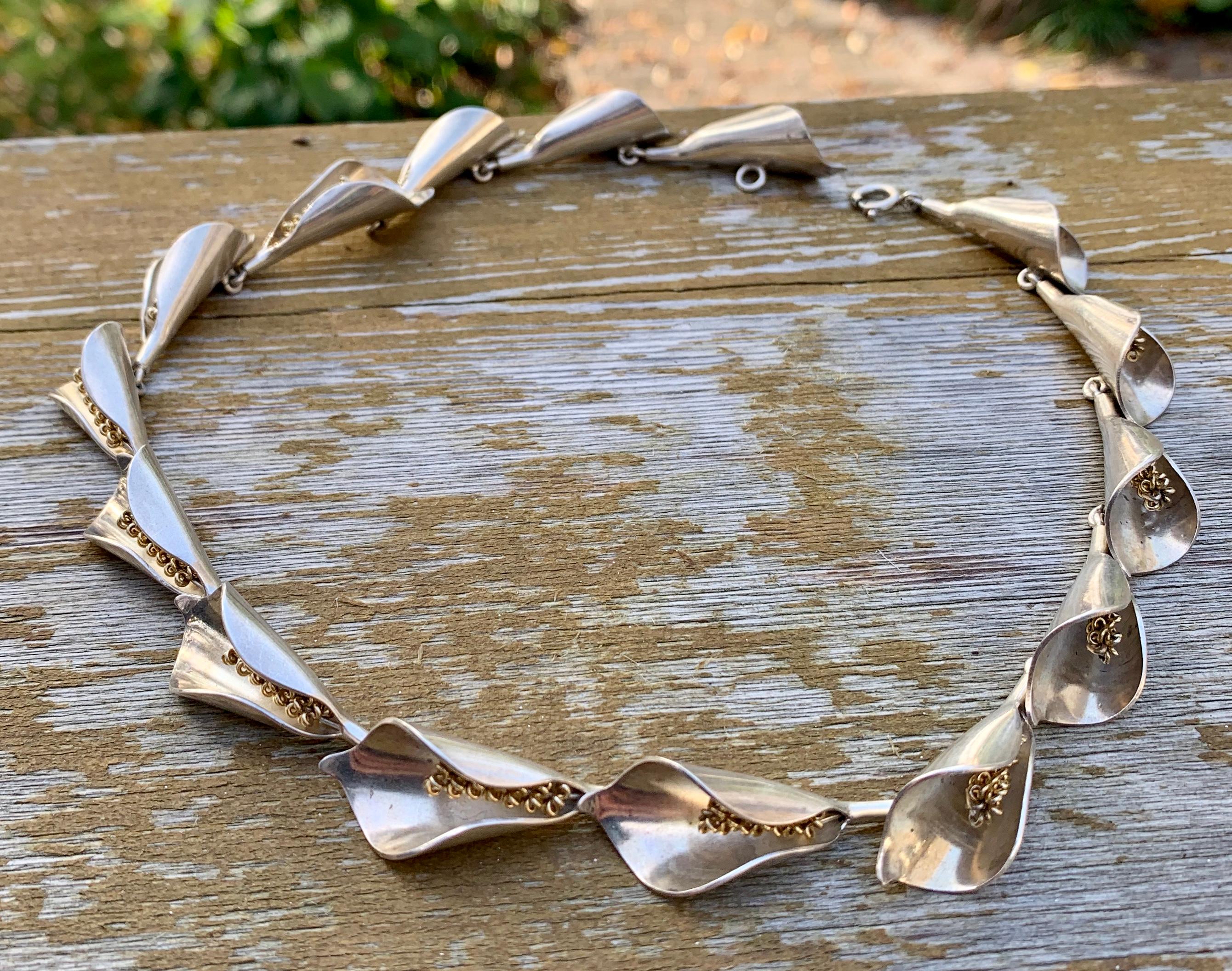 This is the classic Mid-Century Calla Lily Necklace in Sterling Silver made by Danish maker Anton Michelsen and designed by the famous artist Gertrude Engel (Rougie).   The design is a classic of modernism.  It has a wonderful organic feel.  Each